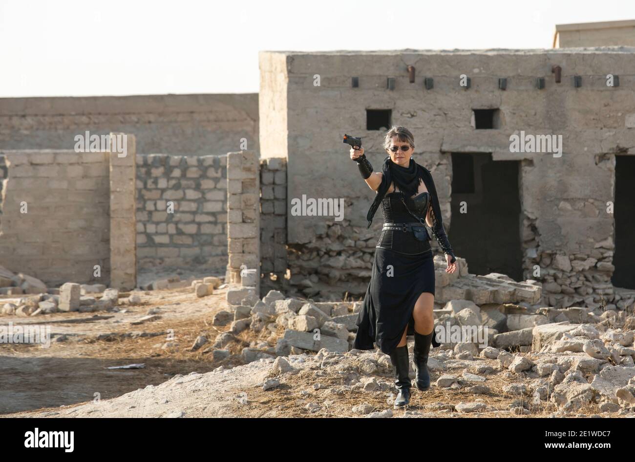 Frau mittleren Alters trägt Steampunk Kostüm der Freiheit Kämpfer in Ihr altes zerstörtes Dorf Stockfoto