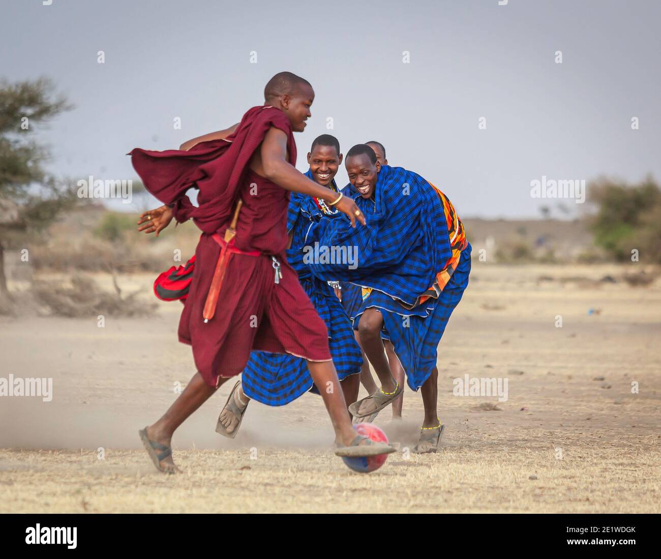 Junge Masai Krieger spielen Fußball in der Savanne Stockfoto