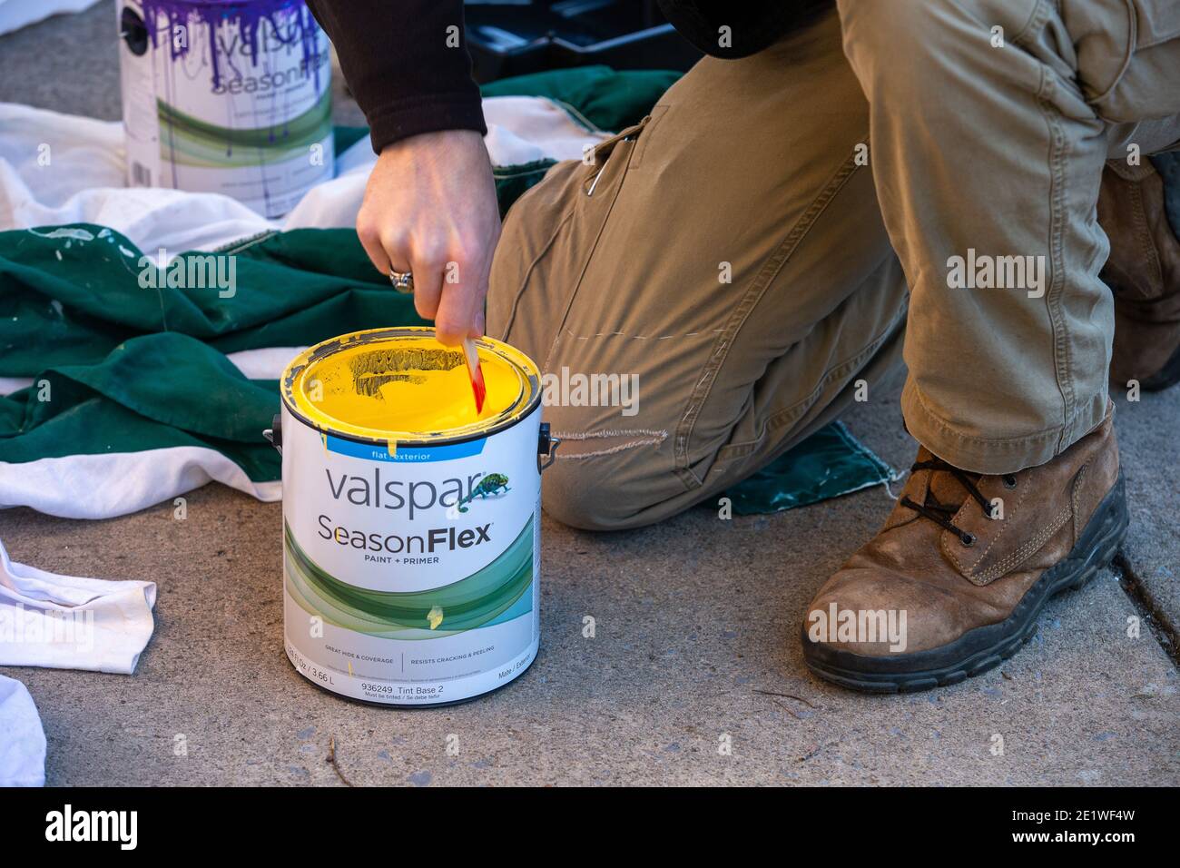 Ein Freiwilliger bereitet Farbe vor, um ein Pride-Wandgemälde neu zu malen, das mit weißen nationalistischen Graffiti besprüht wurde.Dutzende von Community-Mitgliedern versammelten sich bei Jake's Cards and Games, um das defaced Pride-Wandbild auf der Seite des Unternehmens neu zu malen. Freiwillige wechselten sich ab, um die sprühgemalten Botschaften der weißen nationalistischen Gruppe Patriot Front zu übermalen. Stockfoto
