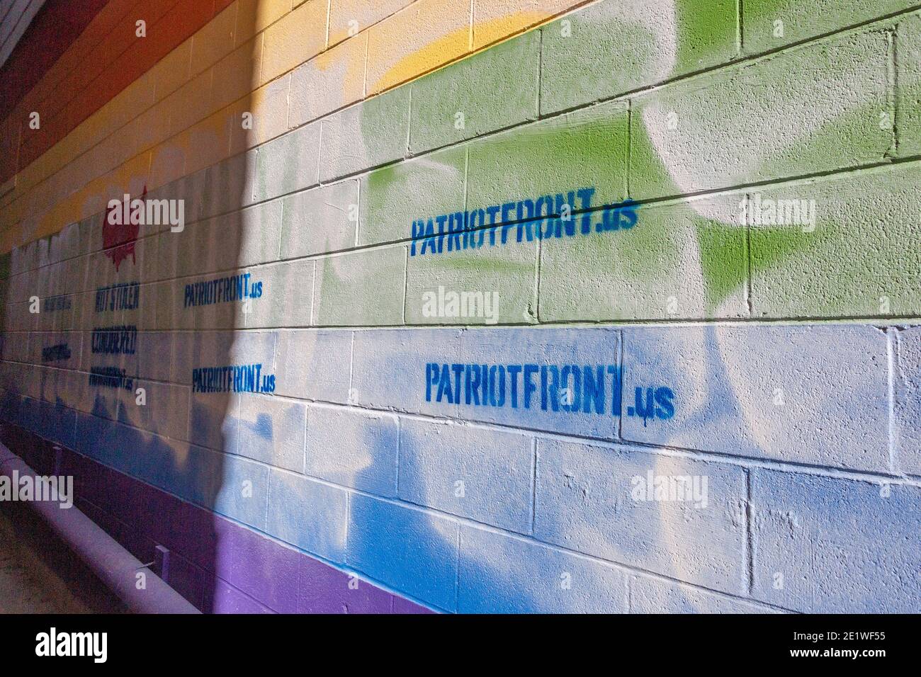 Ein Pride-Wandgemälde an der Außenseite von Jakes Karten- und Spielgeschäft wurde mit schablonierten weißen nationalistischen Botschaften zerstört.Dutzende von Gemeindemitgliedern versammelten sich bei Jakes Karten und Spielen, um das defaced Pride-Wandbild auf der Seite des Geschäfts neu zu malen. Freiwillige wechselten sich ab, um die sprühgemalten Botschaften der weißen nationalistischen Gruppe Patriot Front zu übermalen. Stockfoto
