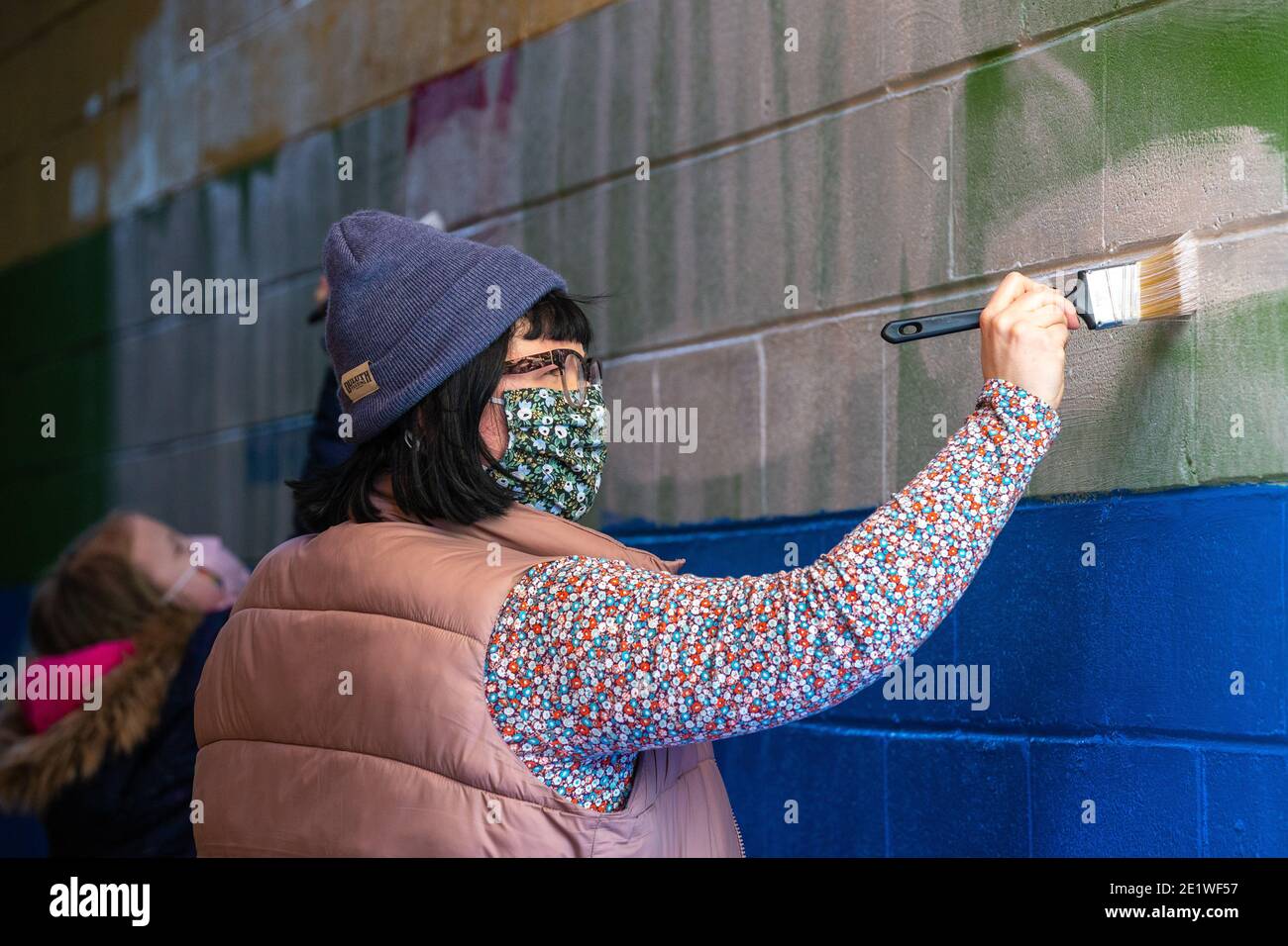 Reverend Jes Kast, Pastor am Faith United Church of Christ im State College, hilft, weiße, supremacist-Graffiti auf einem Pride-Wandbild zu malen.Dutzende von Community-Mitgliedern versammelten sich bei Jake's Cards and Games, um das defaced Pride-Wandbild auf der Seite des Unternehmens neu zu malen. Freiwillige wechselten sich ab, um die sprühgemalten Botschaften der weißen nationalistischen Gruppe Patriot Front zu übermalen. Stockfoto