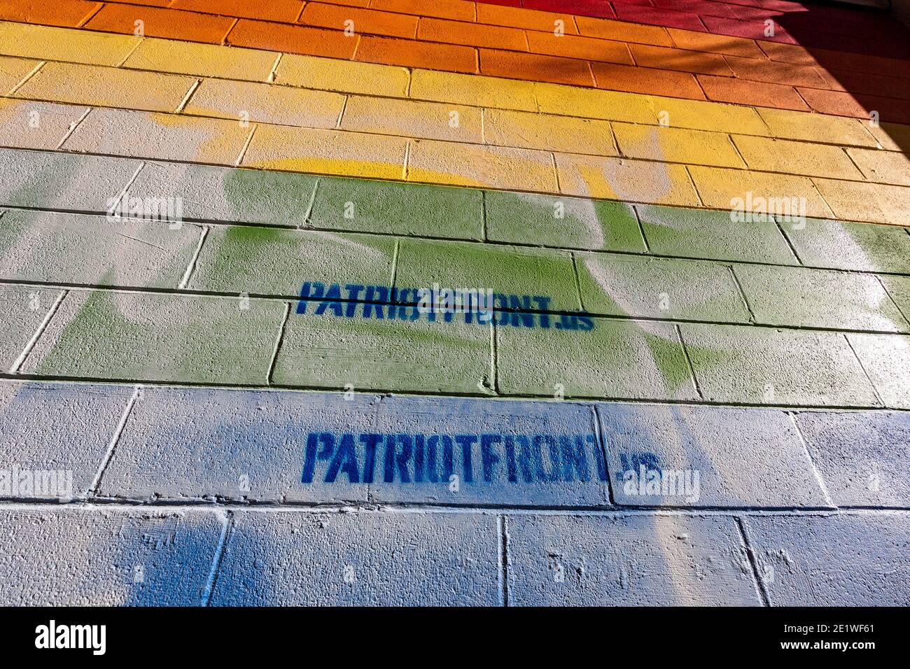 Ein Pride-Wandgemälde an der Außenseite von Jakes Karten- und Spielgeschäft wurde mit schablonierten weißen nationalistischen Botschaften zerstört.Dutzende von Gemeindemitgliedern versammelten sich bei Jakes Karten und Spielen, um das defaced Pride-Wandbild auf der Seite des Geschäfts neu zu malen. Freiwillige wechselten sich ab, um die sprühgemalten Botschaften der weißen nationalistischen Gruppe Patriot Front zu übermalen. Stockfoto