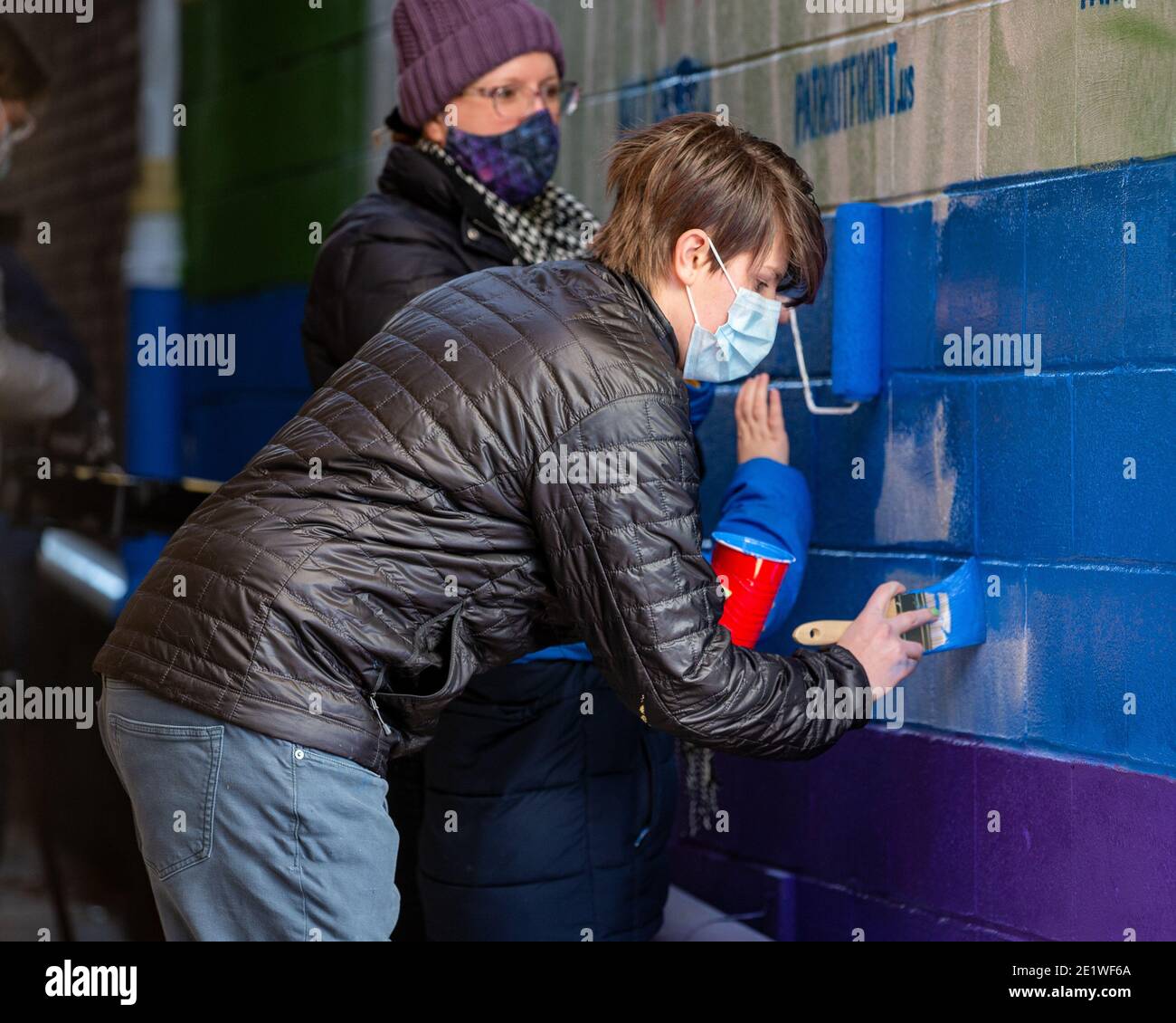 Al Eburne von Bellefonte hilft, ein Wandbild zu übermalen, das mit weißen nationalistischen Graffiti verwüstet wurde.Dutzende von Community-Mitgliedern versammelten sich bei Jake's Cards and Games, um das defaced Pride-Wandbild auf der Seite des Unternehmens neu zu malen. Freiwillige wechselten sich ab, um die sprühgemalten Botschaften der weißen nationalistischen Gruppe Patriot Front zu übermalen. Stockfoto
