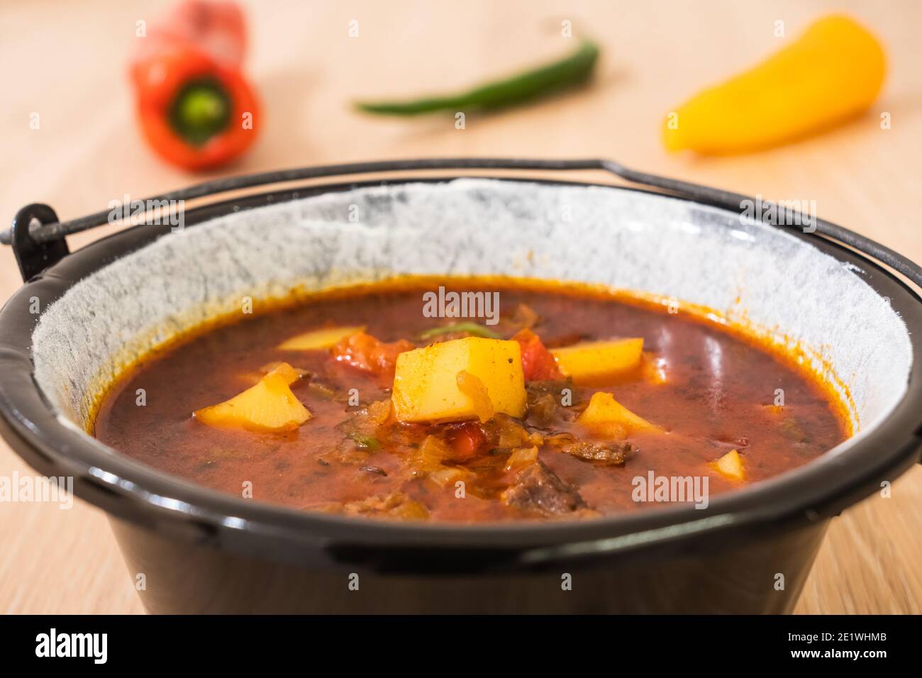 Ungarische Rindergulasch oder Gulyas Suppe oder Eintopf in einem kleinen Kessel mit Kartoffeln, Fleisch, Paprika und Paprika und Chili serviert Stockfoto