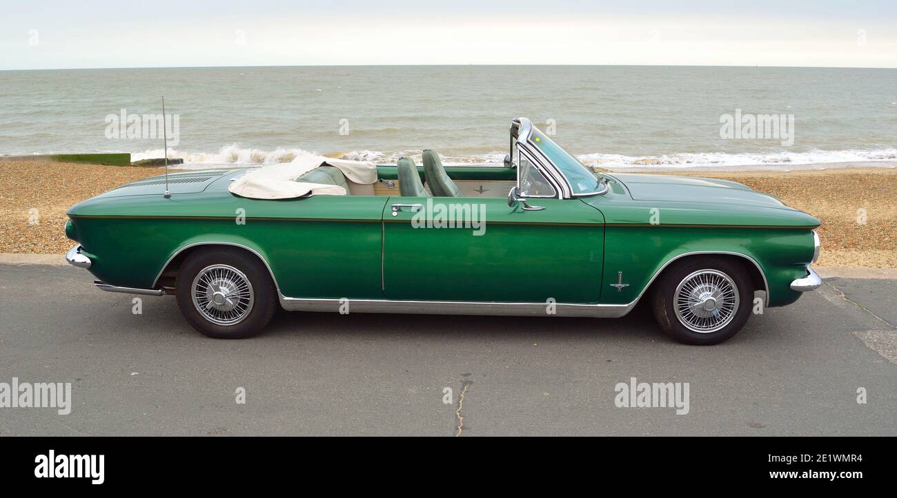 Chevrolet Corvair Cabriolet Classic American Heckmotor Auto geparkt an der Strandpromenade mit dem Meer im Hintergrund. Stockfoto