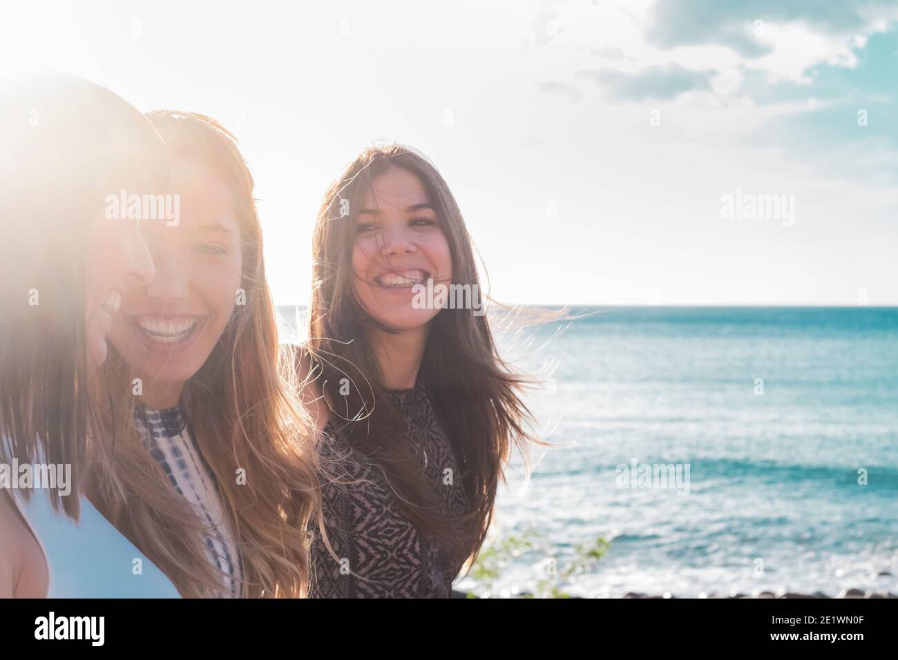 Portrait der Gruppe von jungen Mädchen Freunde lachen und lächeln Gemeinsam Spaß bei Freizeitaktivitäten im Freien mit blauem Meer haben Und Himmel im Hintergrund - glücklich y Stockfoto