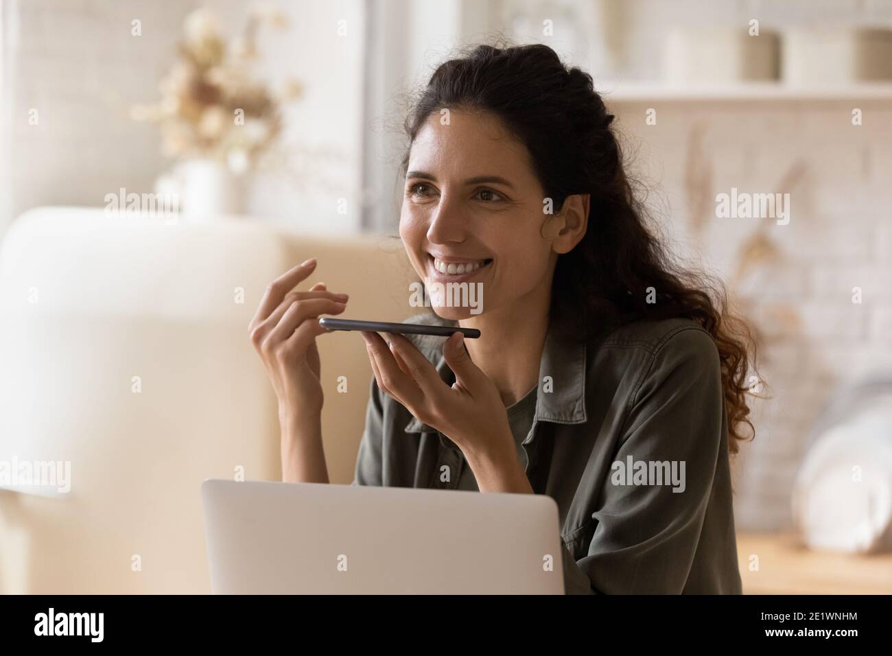 Glückliche junge Frau nehmen Sprachnachricht auf dem Handy auf Stockfoto