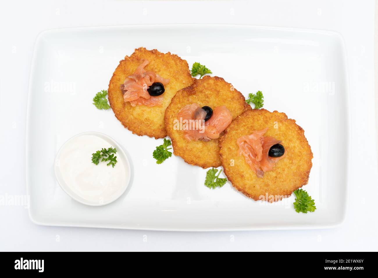 Pfannkuchen mit Lachs, Oliven, Gemüse und Sahne auf weißem Teller und weißem Hintergrund. Stockfoto