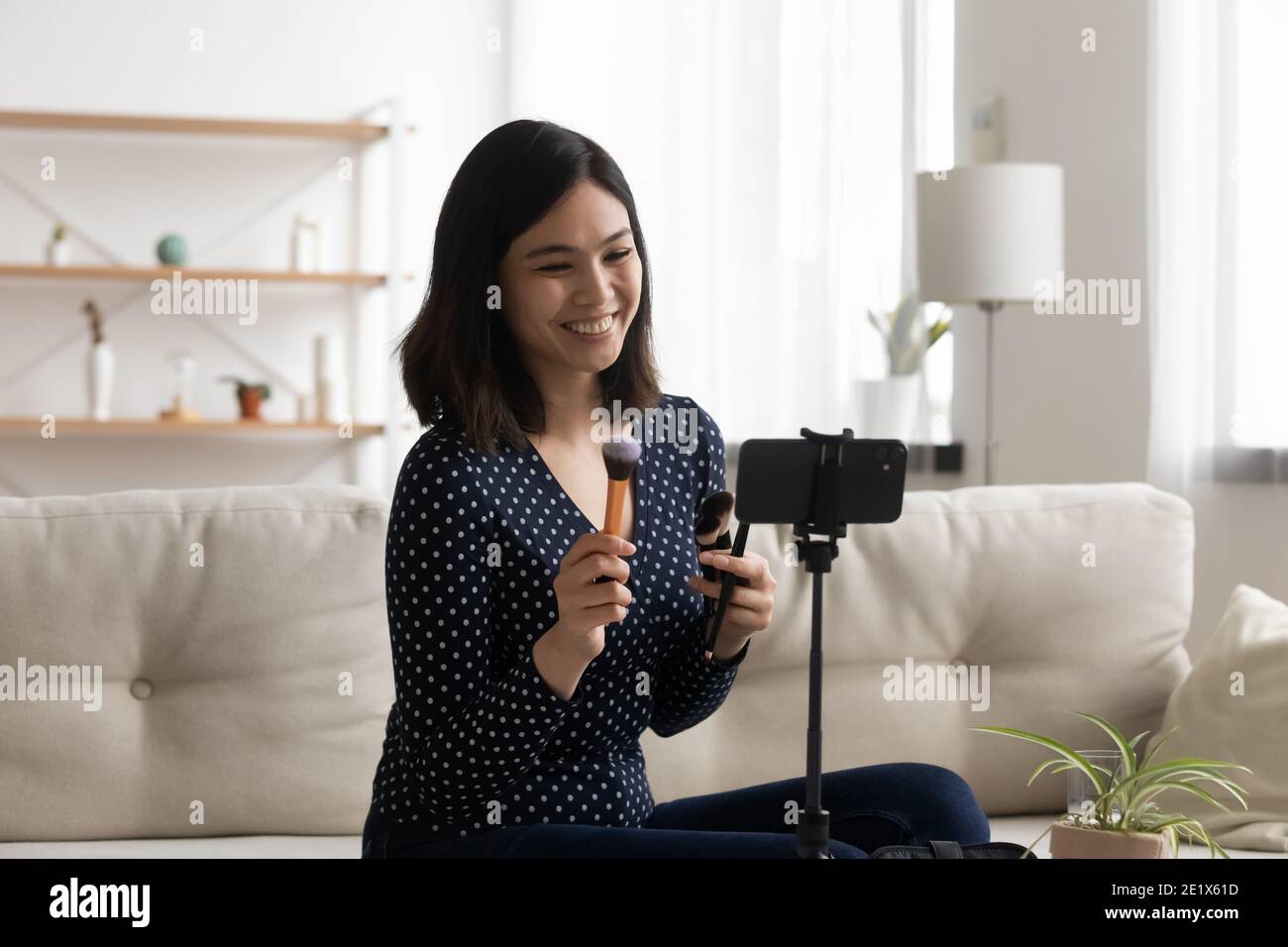 Glücklich junge koreanische Influencer Aufnahme pädagogische Make-up-Video. Stockfoto