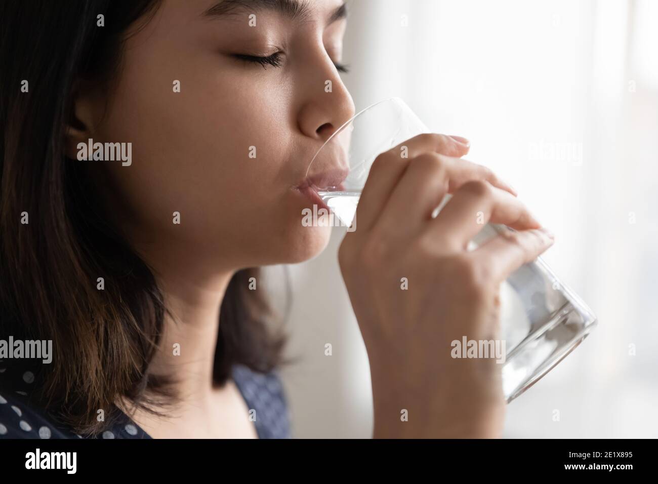 Millennial gemischte Rasse Frau trinken kristallklares Wasser. Stockfoto