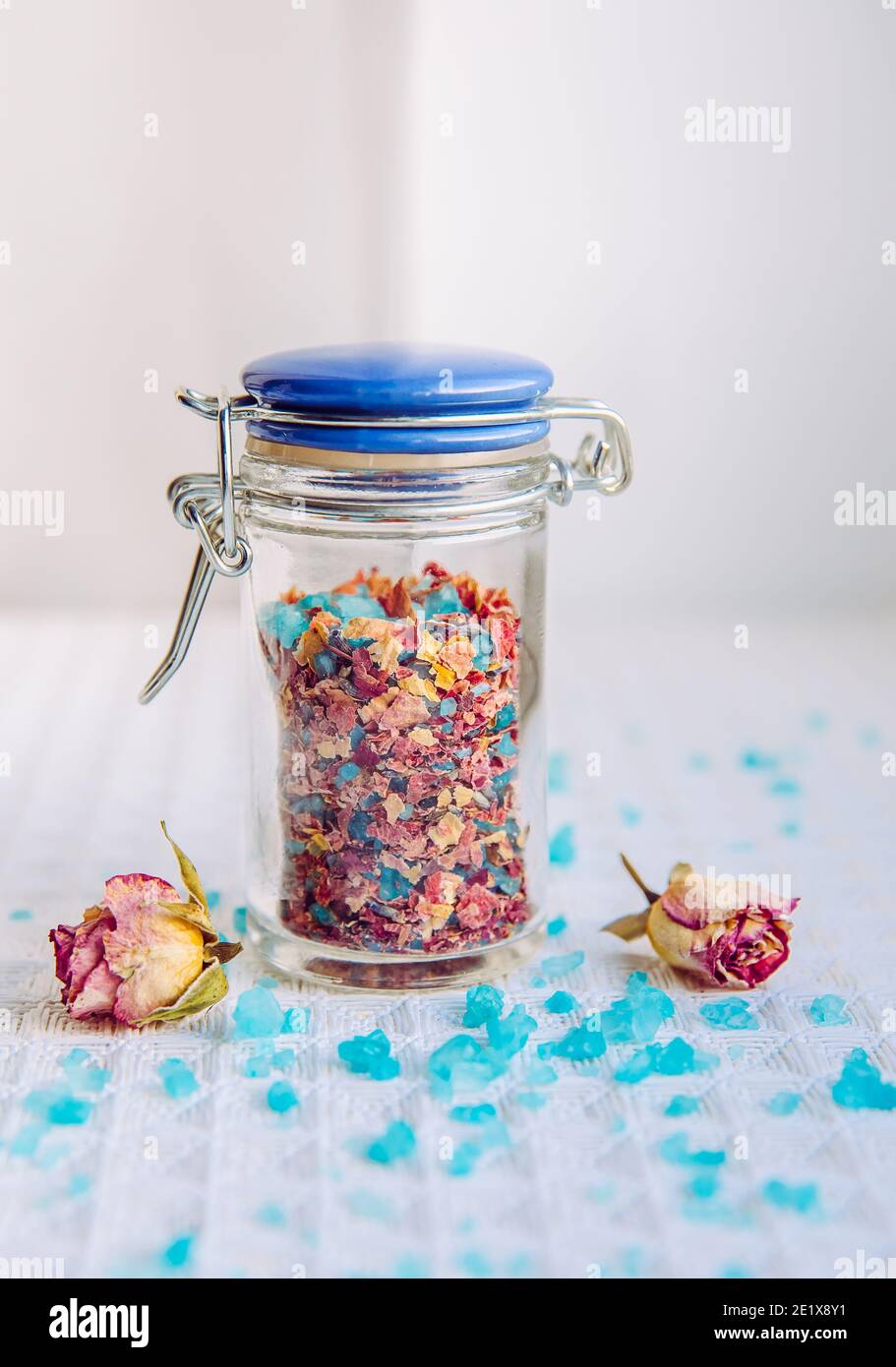 Hausgemachte trockene Rosenblüten Blumenbad Salzmischung für Aromatherapie und Entspannung in Badewanne, Bad Mischung. Innen kleine niedliche Glas. Badesalz mit Kraut gemischt Stockfoto