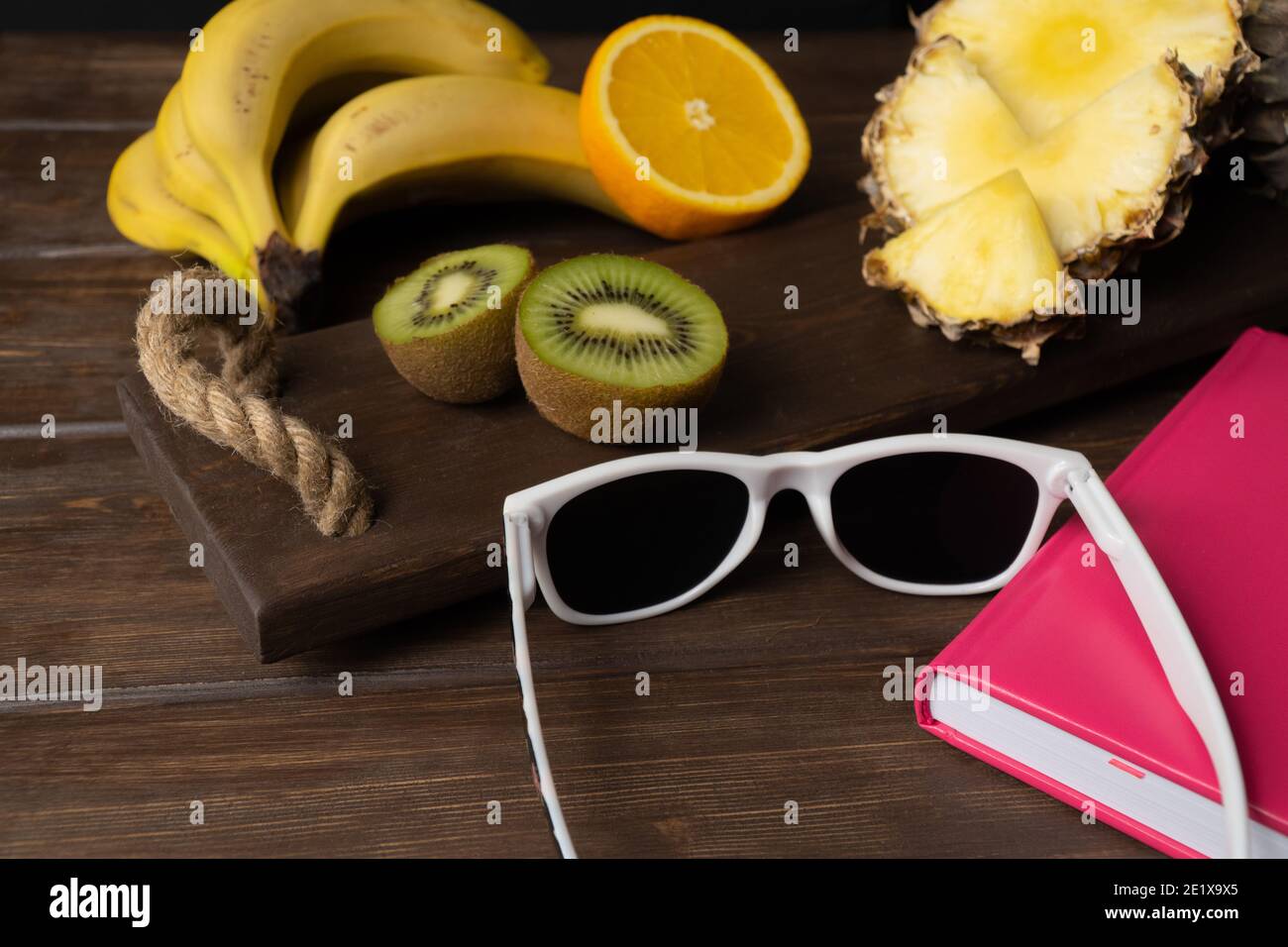 Sonnenbrillen und Obst auf dem Tisch. Das Konzept eines Urlaubs in tropischen Ländern. Exotische Früchte im Urlaub. Sommerstimmung Stockfoto