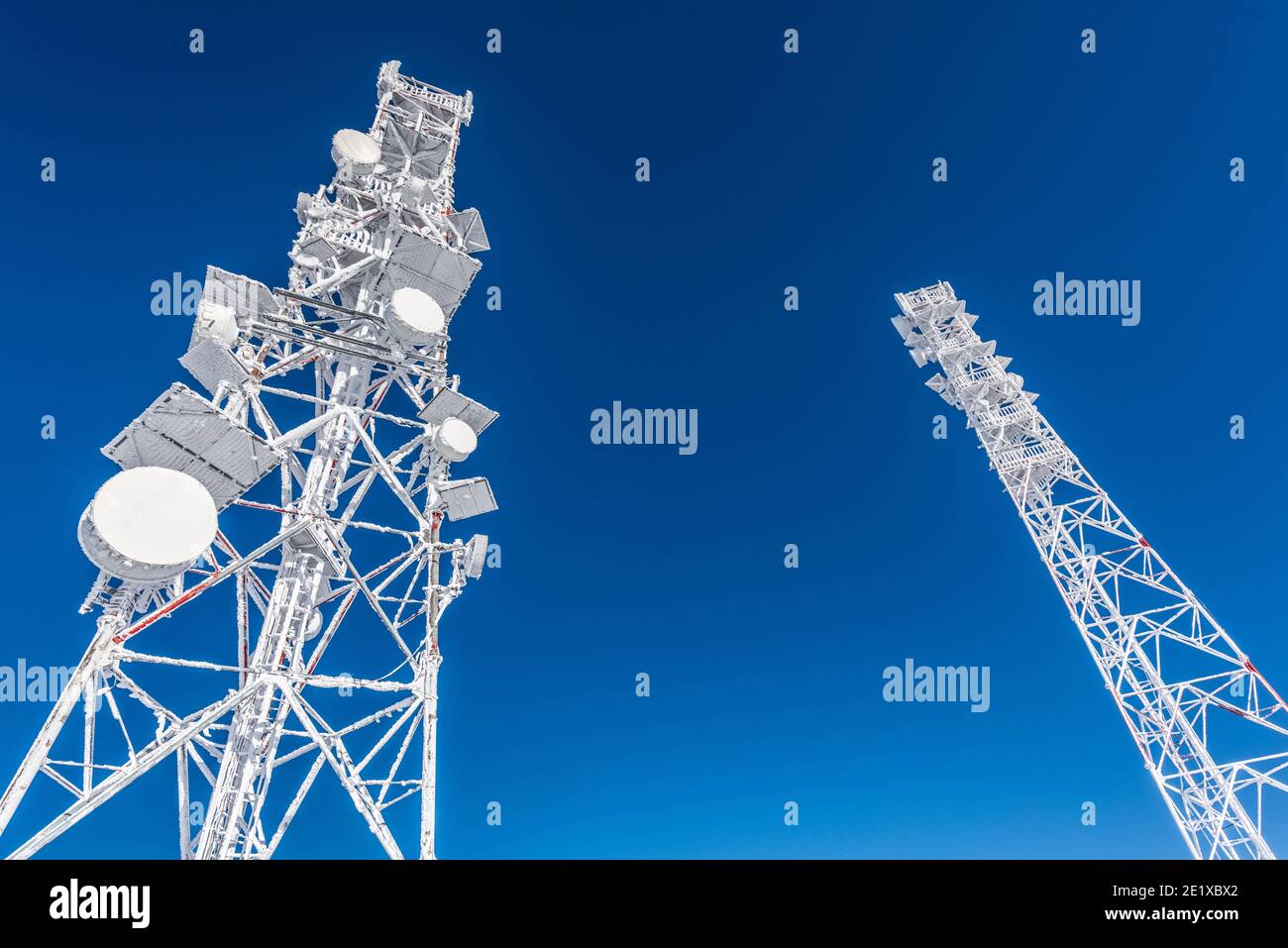 Eisbedeckter Zellenturm auf dem Dach der Basis-Funkstation im Hochland. Mobilfunkstation. Wetterstation. Stockfoto