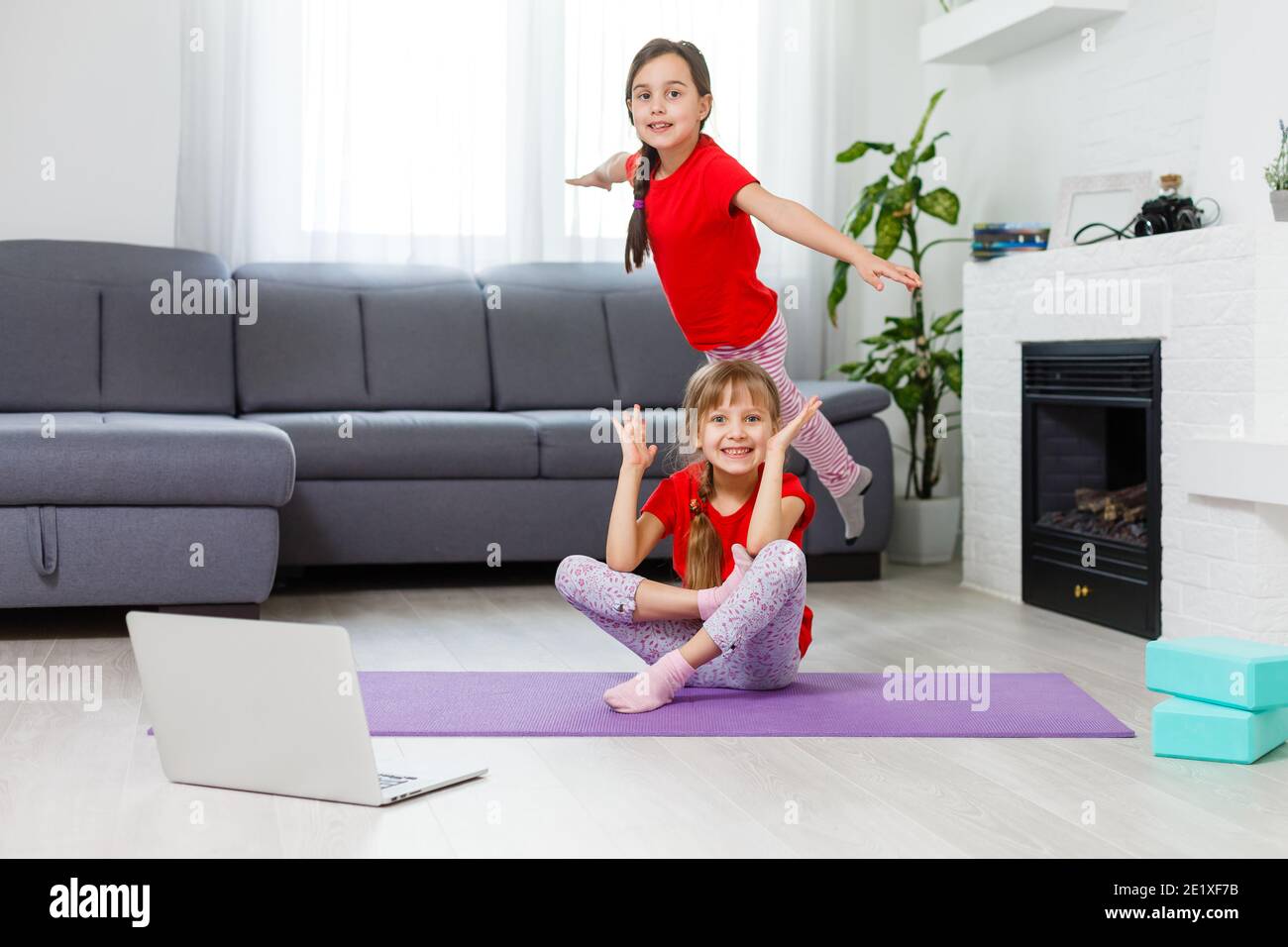 Full-length image kleine Mädchen mit Spaß zu Hause sportliche aktive Kind Mädchen. Lustige Freizeitaktivitäten, sportlich gesundes Lifestyle-Konzept Stockfoto