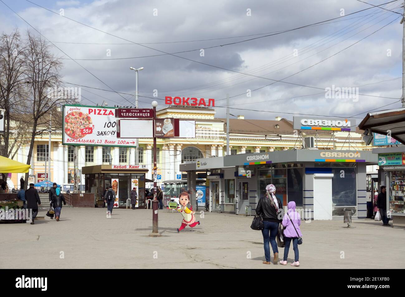 Tauschen Sie Pavillons auf dem Bahnhofsplatz aus, und gehen Sie an einem bewölkten Frühlingstag vor dem Bahnhof (1914). Stockfoto
