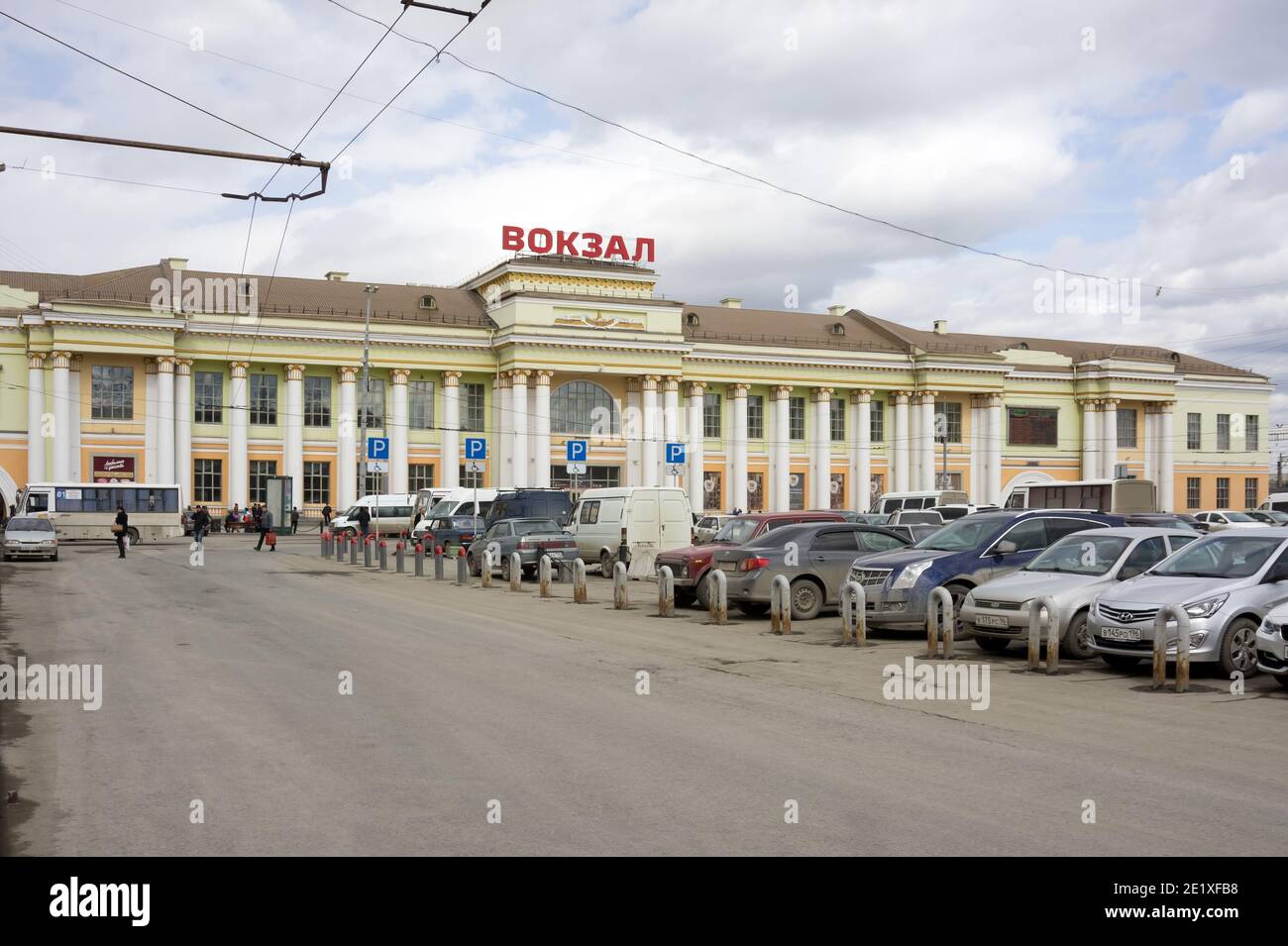 Der Hauptbahnhof (1914) der Stadt von der Seite des Bahnhofs Platz mit geparkten Autos an einem bewölkten Frühlingstag. Stockfoto