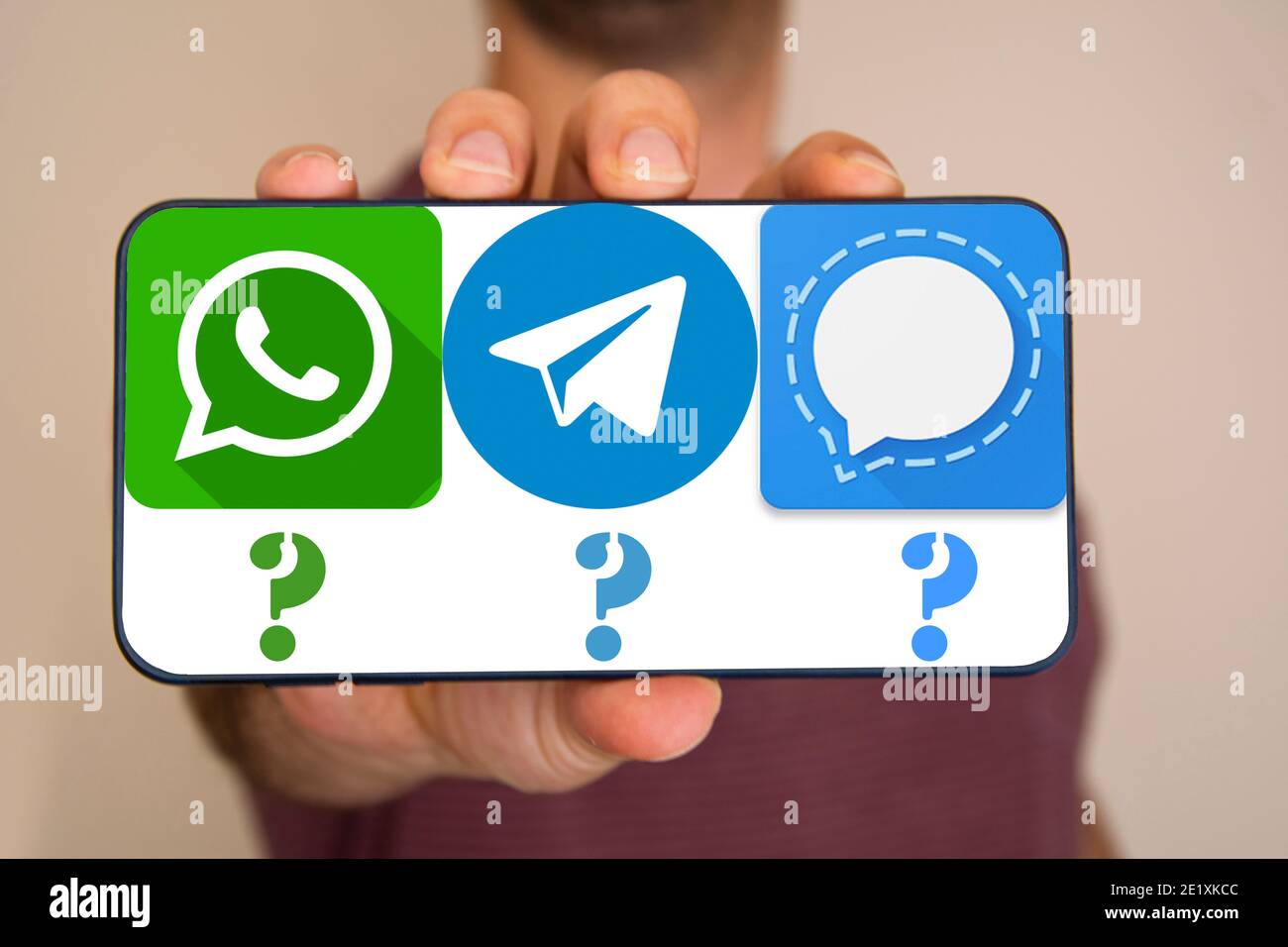 Der nicht erkennbare Mann hält das Telefon mit Whatsapp, Telegram, Signal-Icons auf dem Bildschirm. Stockfoto