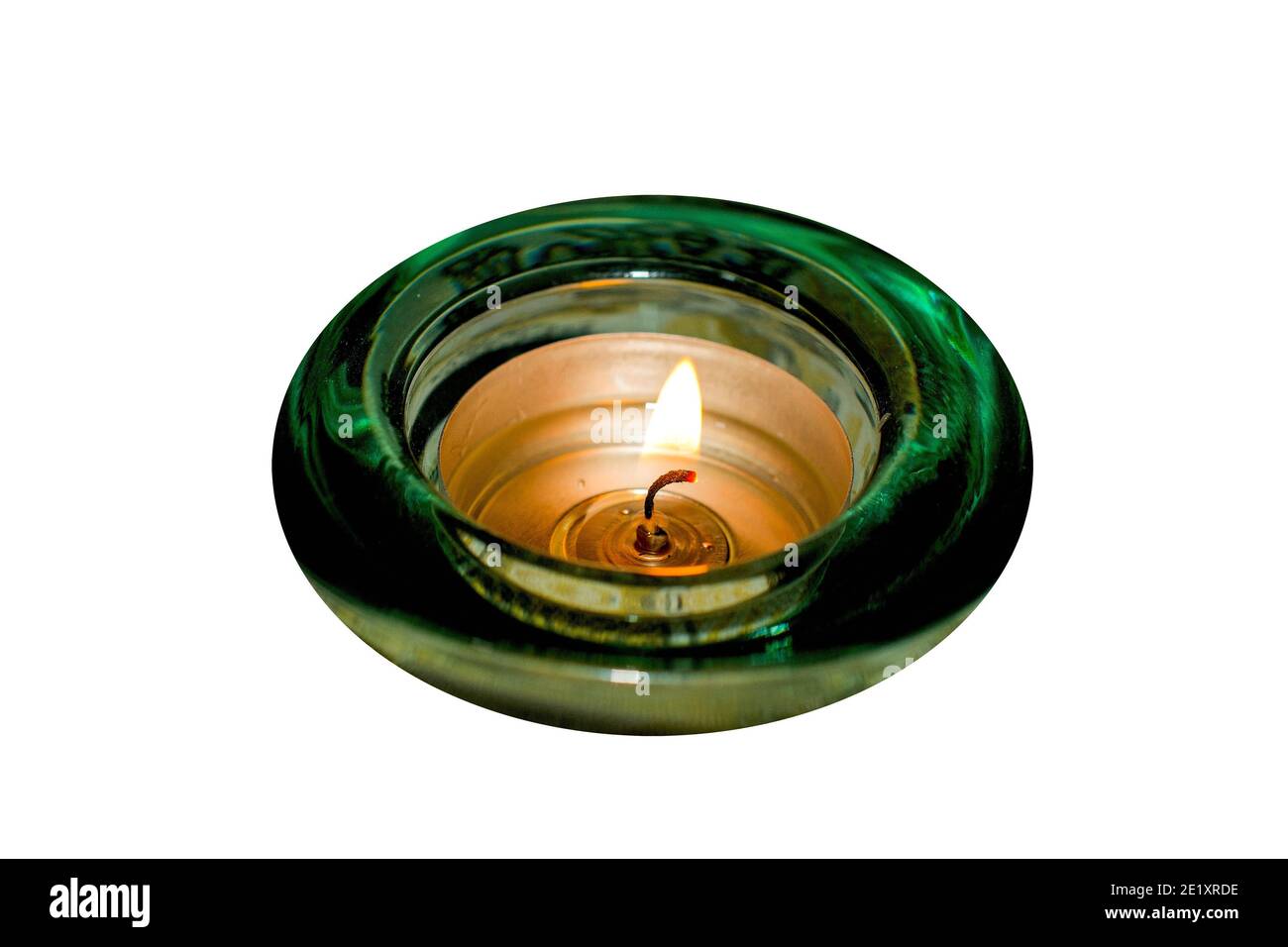 Brennende Kerze in grünem Glashalter auf weißem Hintergrund. Eine Zeit der Wunscherfüllung. Stockfoto