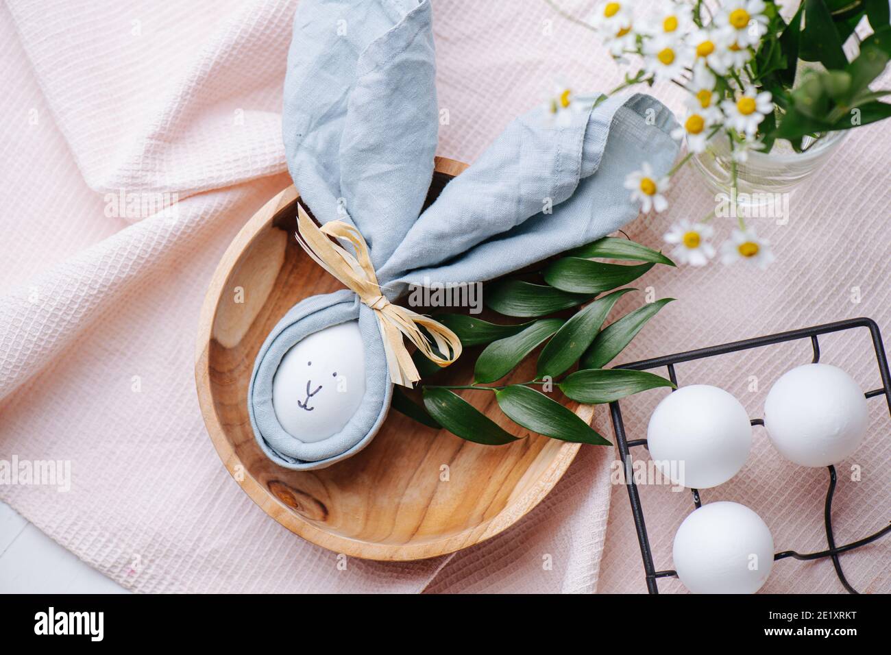 Handgefertigtes Kaninchen aus Eiern und Servietten auf einem Holzteller Stockfoto