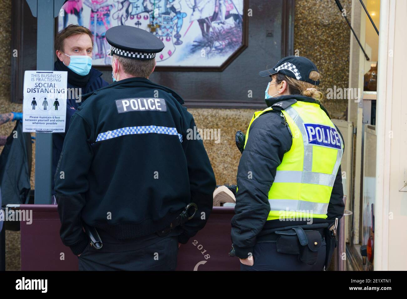 Portobello, Schottland, Großbritannien. 10. Januar 2021. Trotz einer derzeit in Schottland erzwungenen nationalen Sperre waren Portobello Promenade und Strand mit einer großen Anzahl von Menschen beschäftigt, die dort am Sonntagnachmittag waren. Mehrere Polizeipatrouillen waren offensichtlich, dass sie meist unauffällig blieben, aber die Beamten sprachen mit den Kaffeehäffern, um sie zu drängen, die soziale Distanz zwischen den Kunden korrekt zu halten. PIC; die Polizei spricht mit dem Manager des Cafés, um die soziale Distanzierung zu erklären. Iain Masterton/Alamy Live News Stockfoto