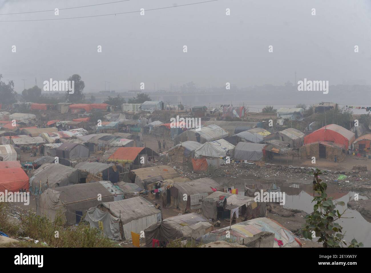 Pakistanische Pendler machen ihren Weg inmitten dichten Nebel auf ein Kalter Wintermorgen in Lahore Stockfoto