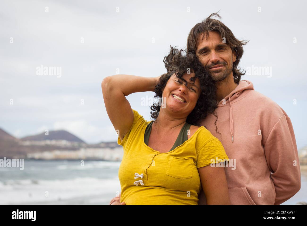 Lächelndes Paar, das die Kamera anschaut. Romantische Liebhaber genießen Strandspaziergang auf legerer Kleidung. Dating, Valentinstag Konzept Stockfoto