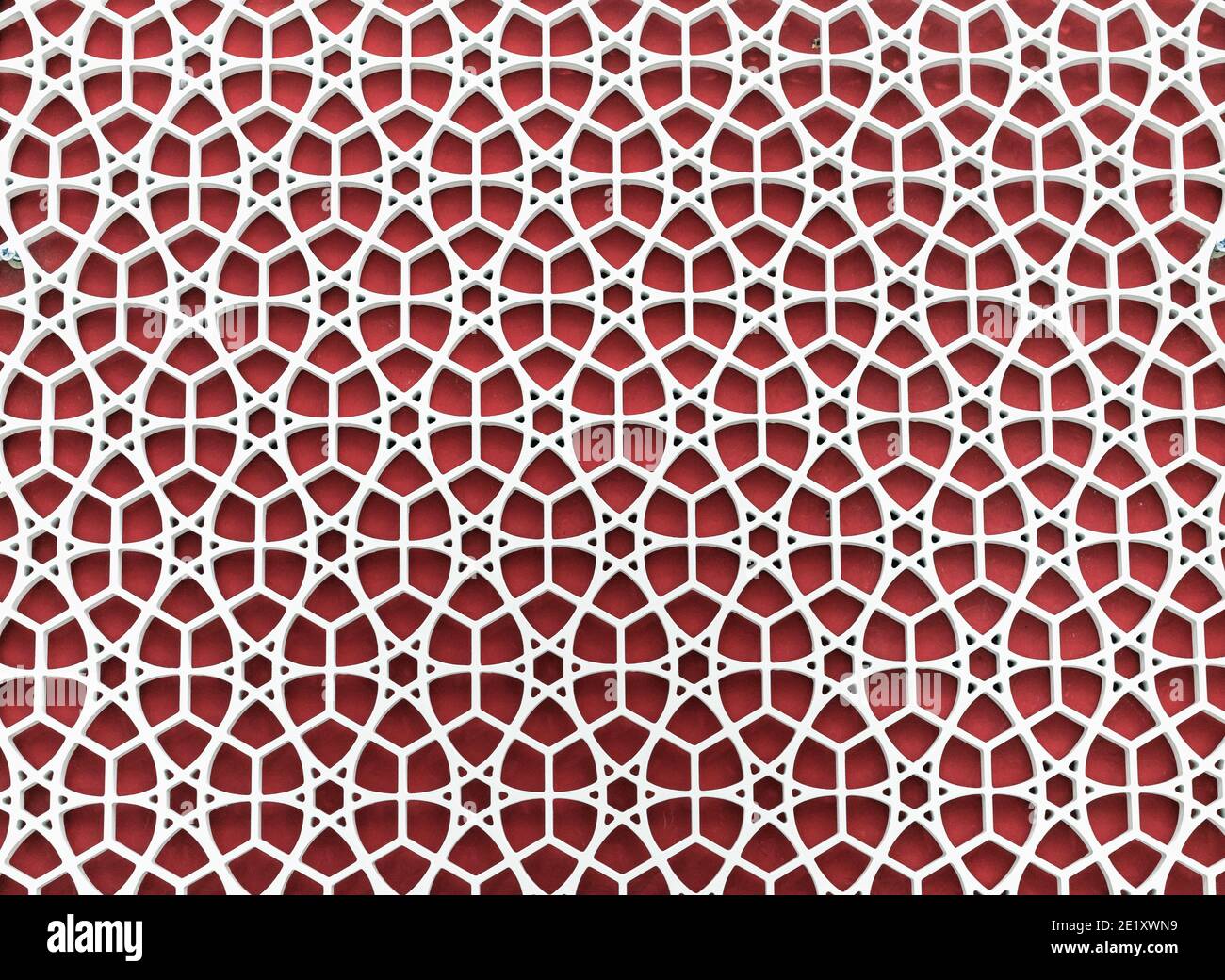Spitzengitter auf rotem Hintergrund. Spitzenstruktur. Geometrisches Ornament. Stockfoto