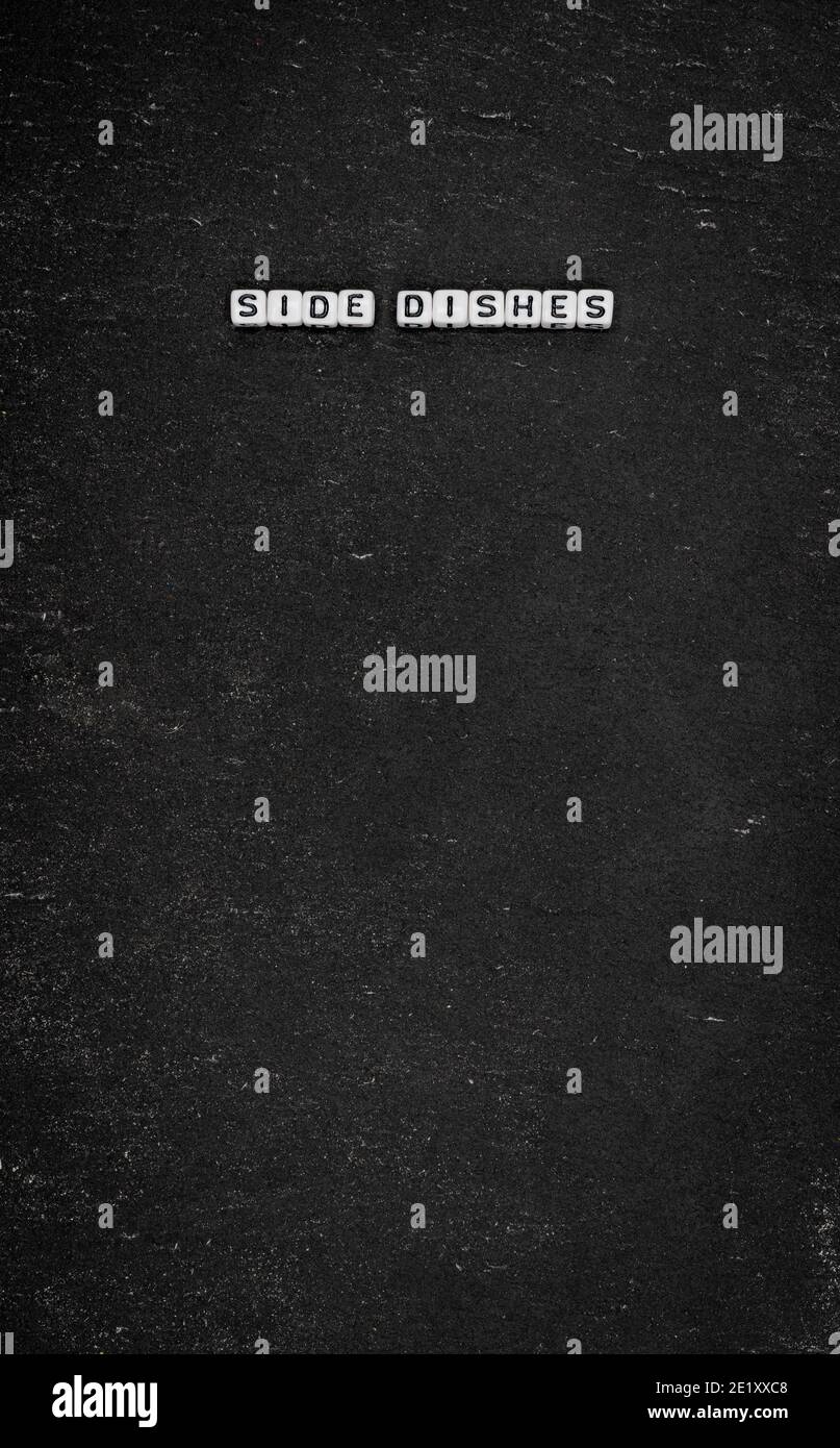 Wort Beilagen auf schwarzem Stein Hintergrund Stockfoto