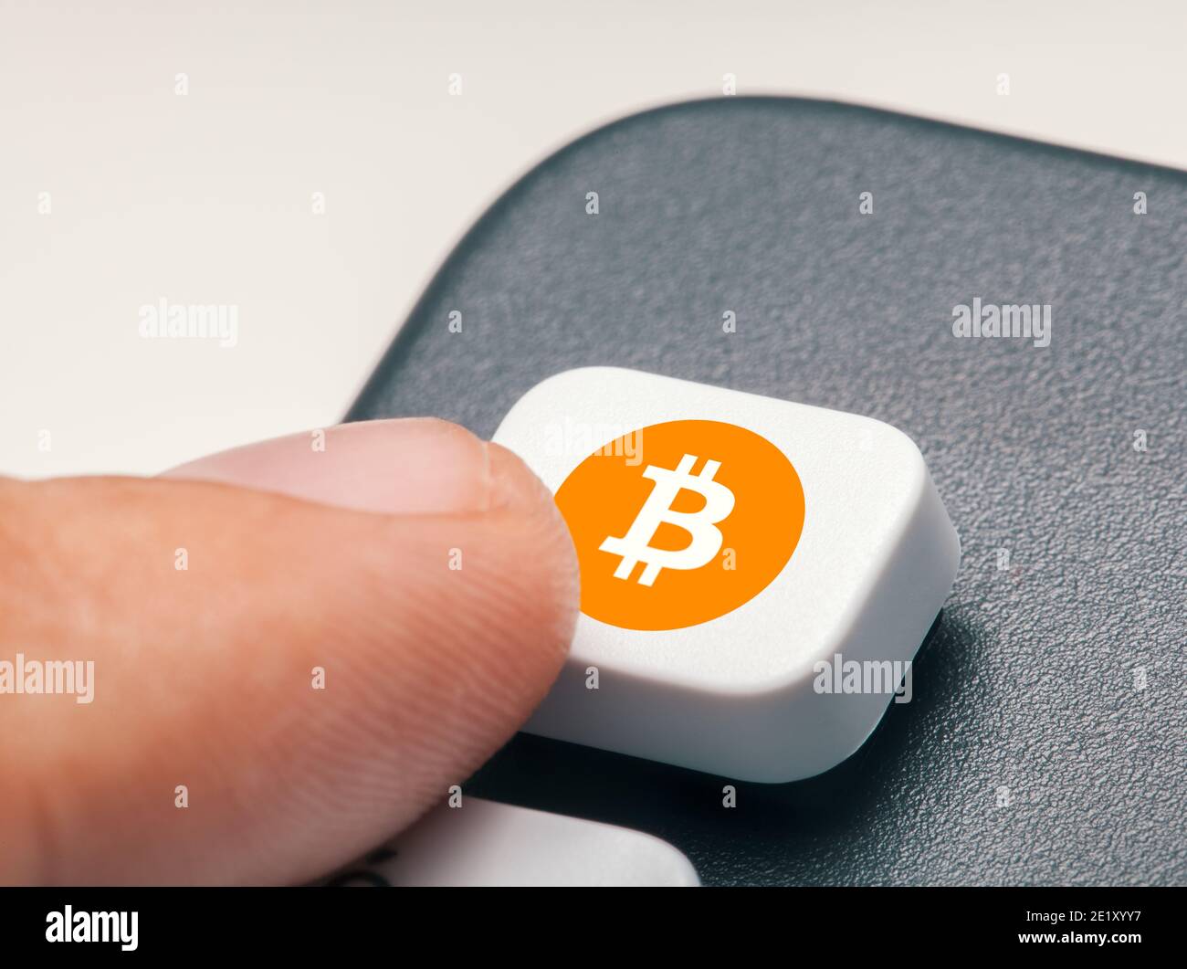 Finger drücken Computer-Taste mit Bitcoin-Logo. Krypto-Bergbau-Trading-Konzept Stockfoto