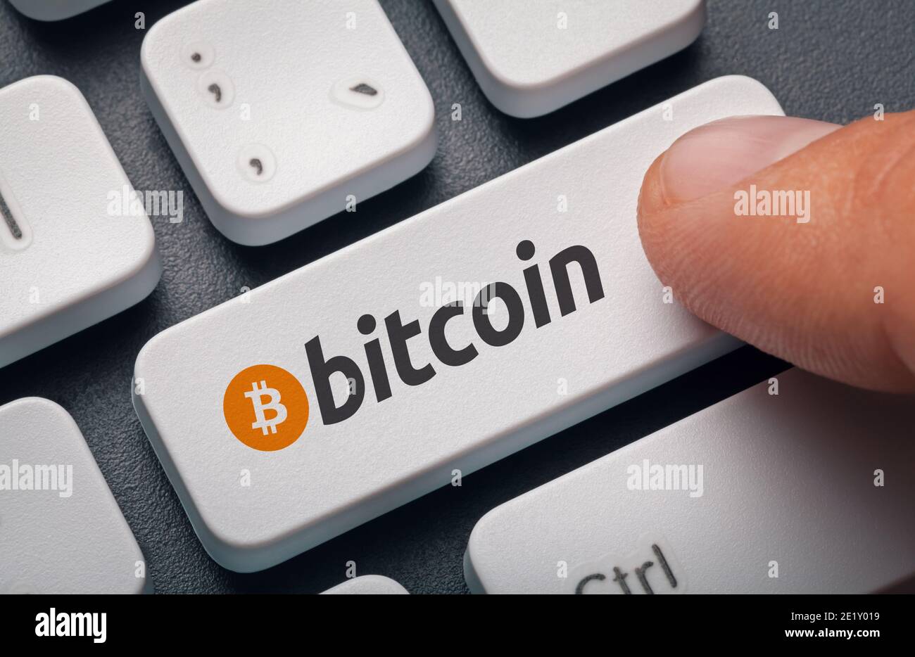 Finger drücken Computer-Taste mit Bitcoin-Logo. Krypto-Mining-Konzept Stockfoto