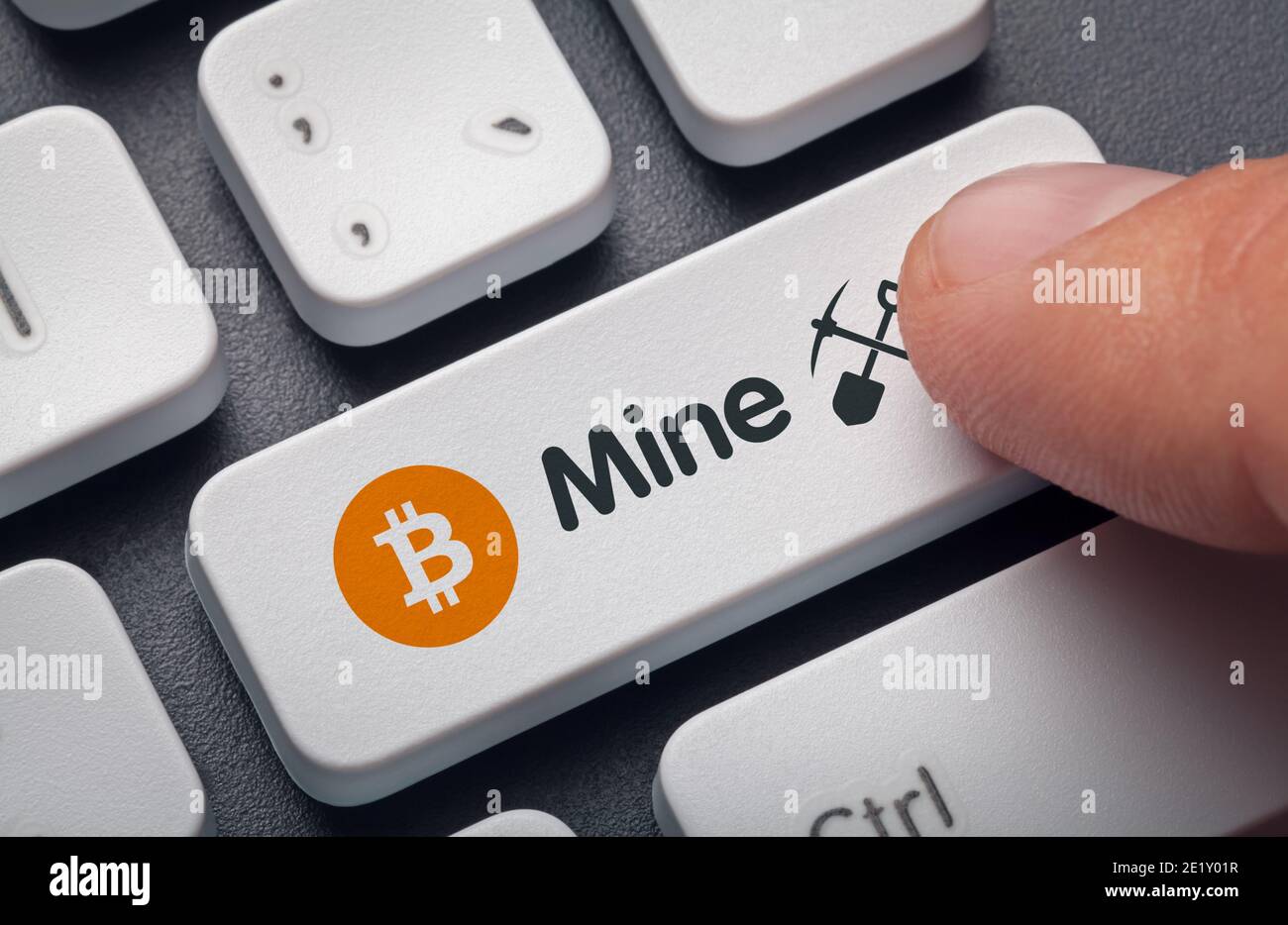 Finger drücken Computer-Taste mit Bitcoin-Symbol, Mine Wort und Symbol. Krypto-Mining-Konzept. Stockfoto