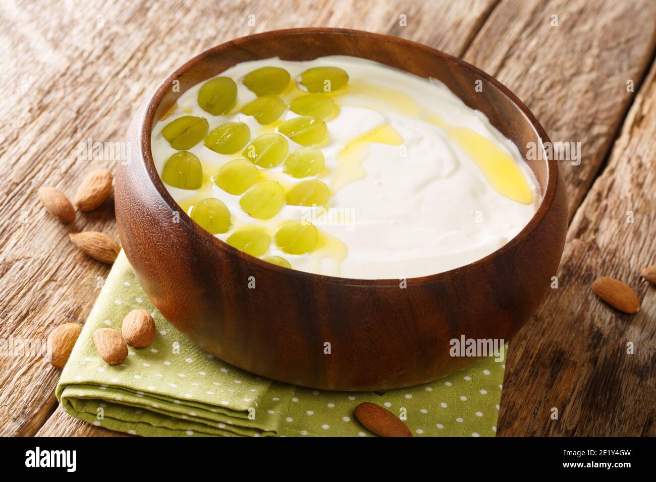 Spanische kalte Suppe aus gehackten Mandeln, Brot und Knoblauch serviert mit grünen Trauben close-up in einer Schüssel auf dem Tisch. Horizontal Stockfoto