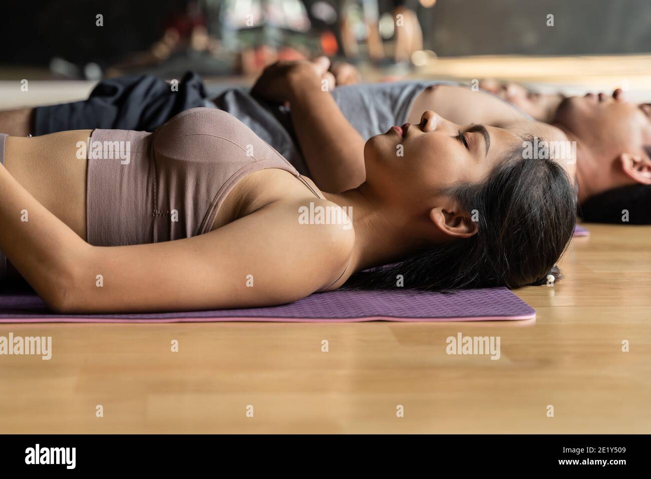 Seitenansicht der fokussierten jungen, vielfältigen Gruppe von Athleten üben Fitness gemeinsam auf Matten im Fitnessstudio liegen - Selective Fokus Stockfoto