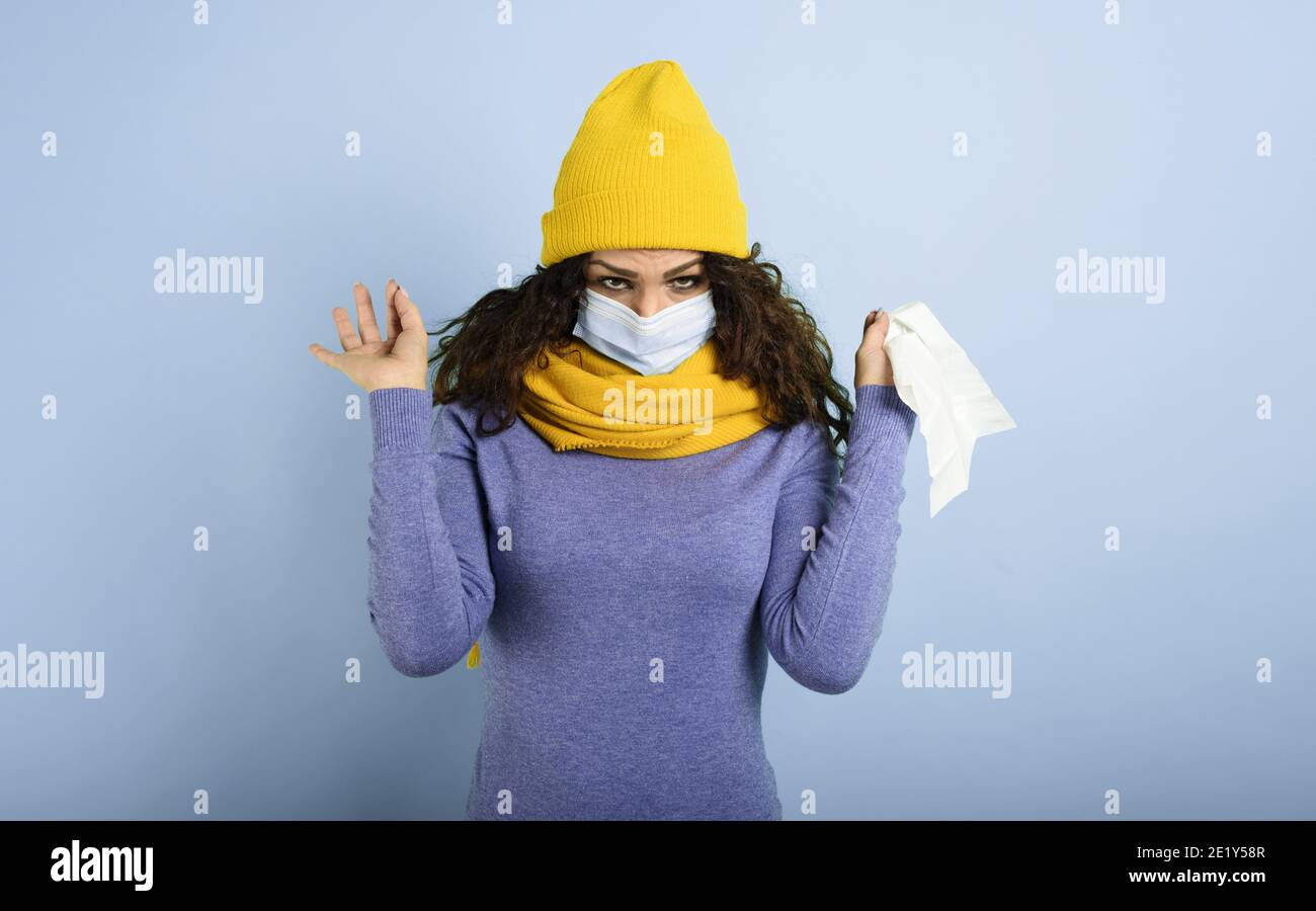 Mädchen mit Maske fing eine Erkältung. Violetter Hintergrund Stockfoto