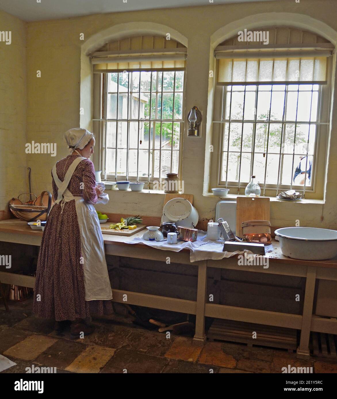 Viktorianische Küche Zimmermädchen, die Essen durch Fenster.. Stockfoto