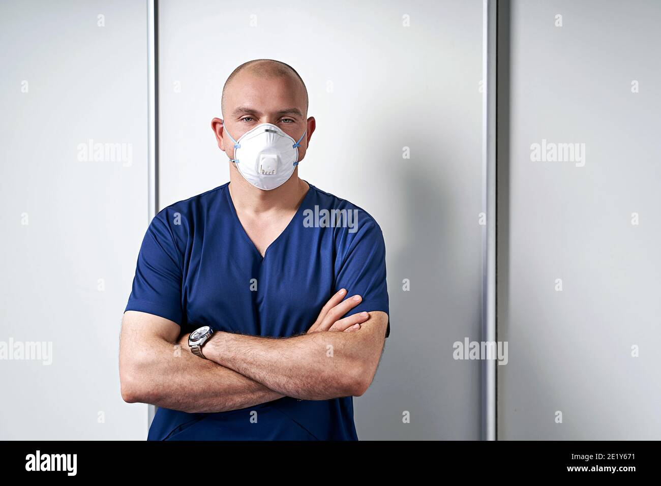 Erfahrene männliche Masseur Masseur in seinem medizinischen Büro stehend Durch einen Massageliegen tragen professionelle Uniform und Einweg-Standard N95 Stockfoto