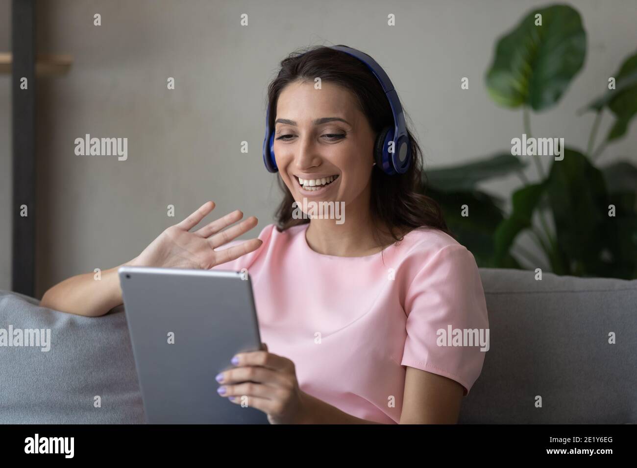 Lächelnde indische arabische Frau sprechen auf Tablet Stockfoto
