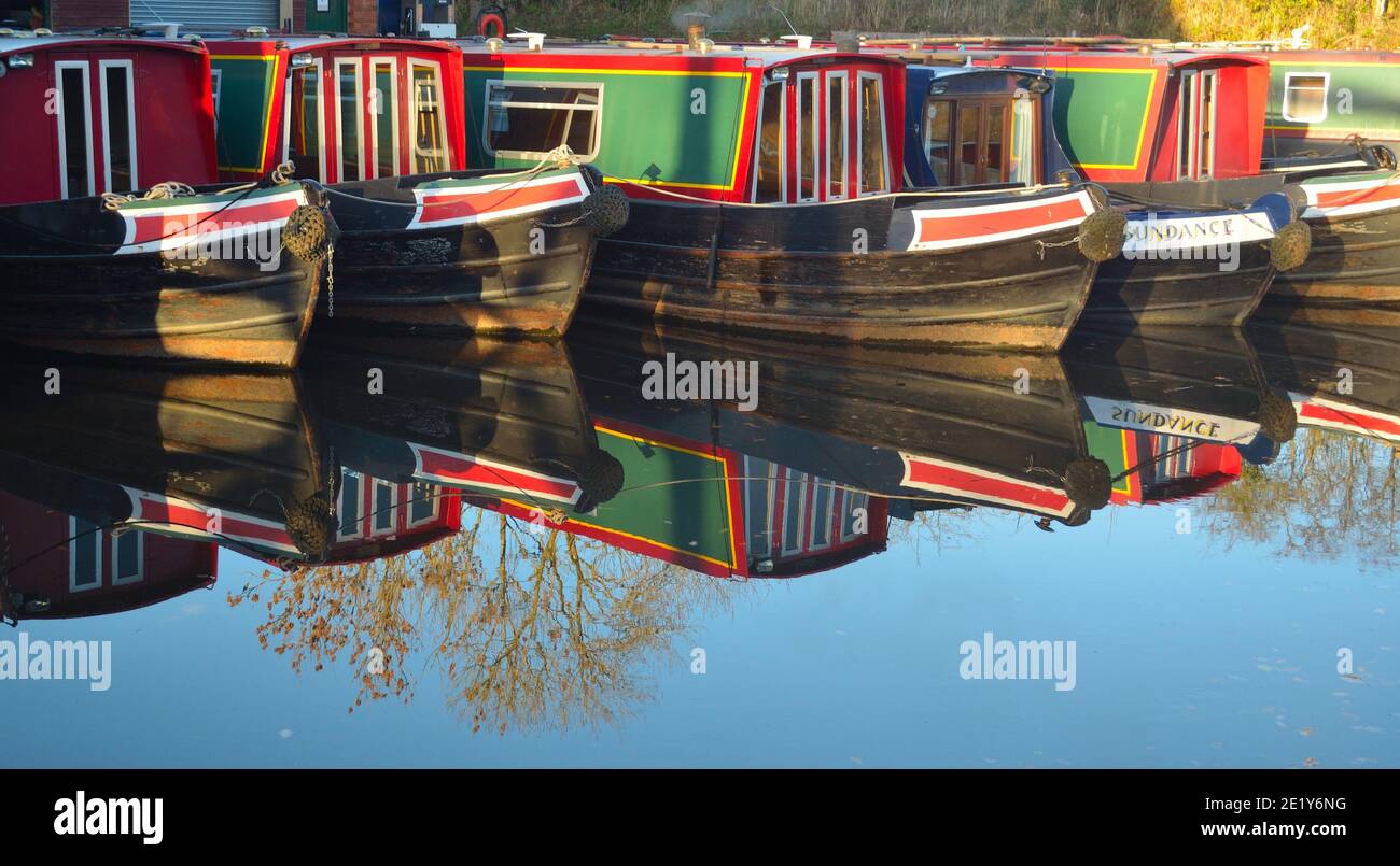 Schmale Boote, die in Wrenbury am Llangollen-Kanal festgemacht sind, Boote und Spiegelungen Stockfoto