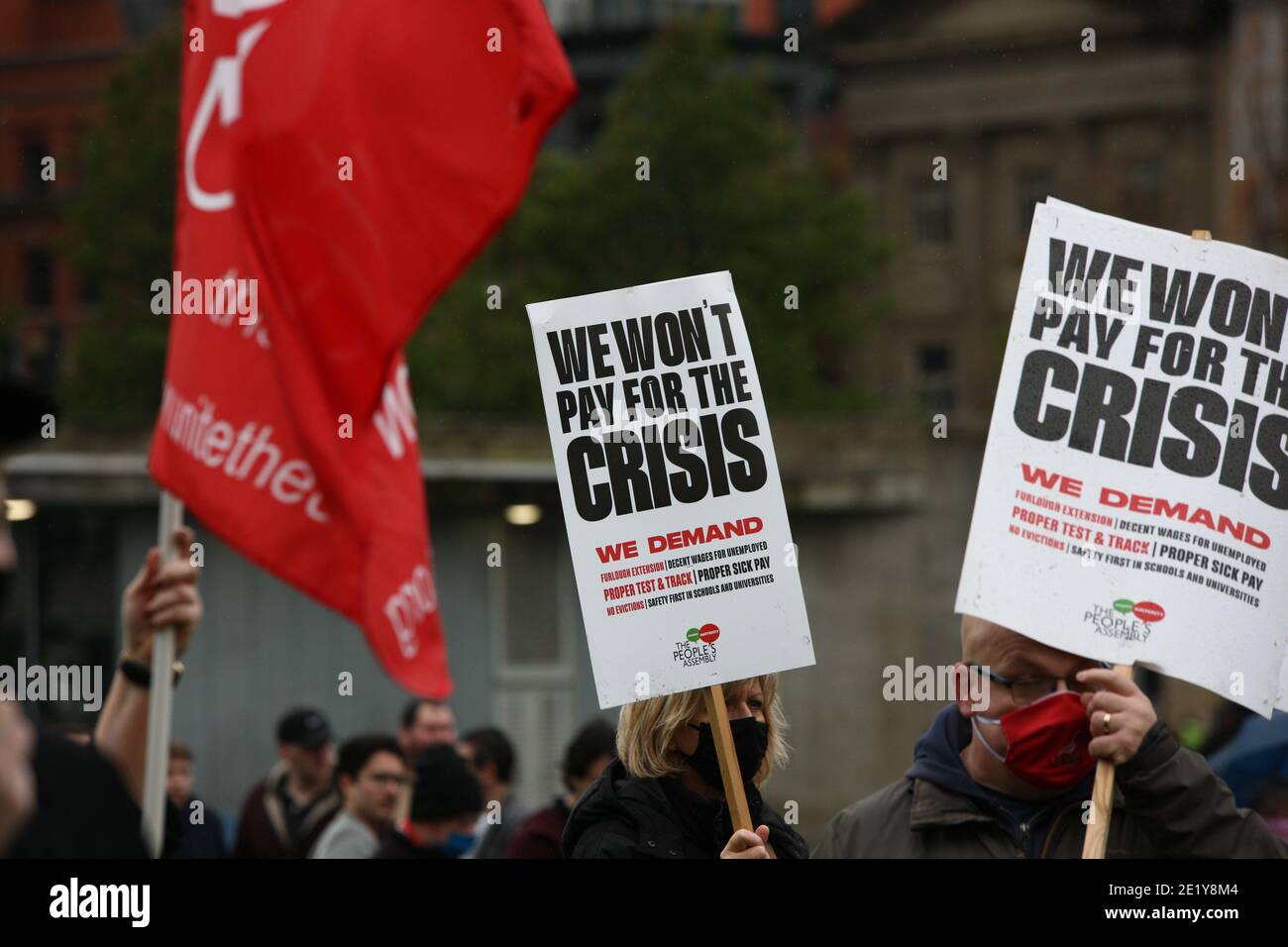 Menschen halten am Samstag bei einer Volksversammlung in Piccadilly Gardens Zeichen hoch. Stockfoto