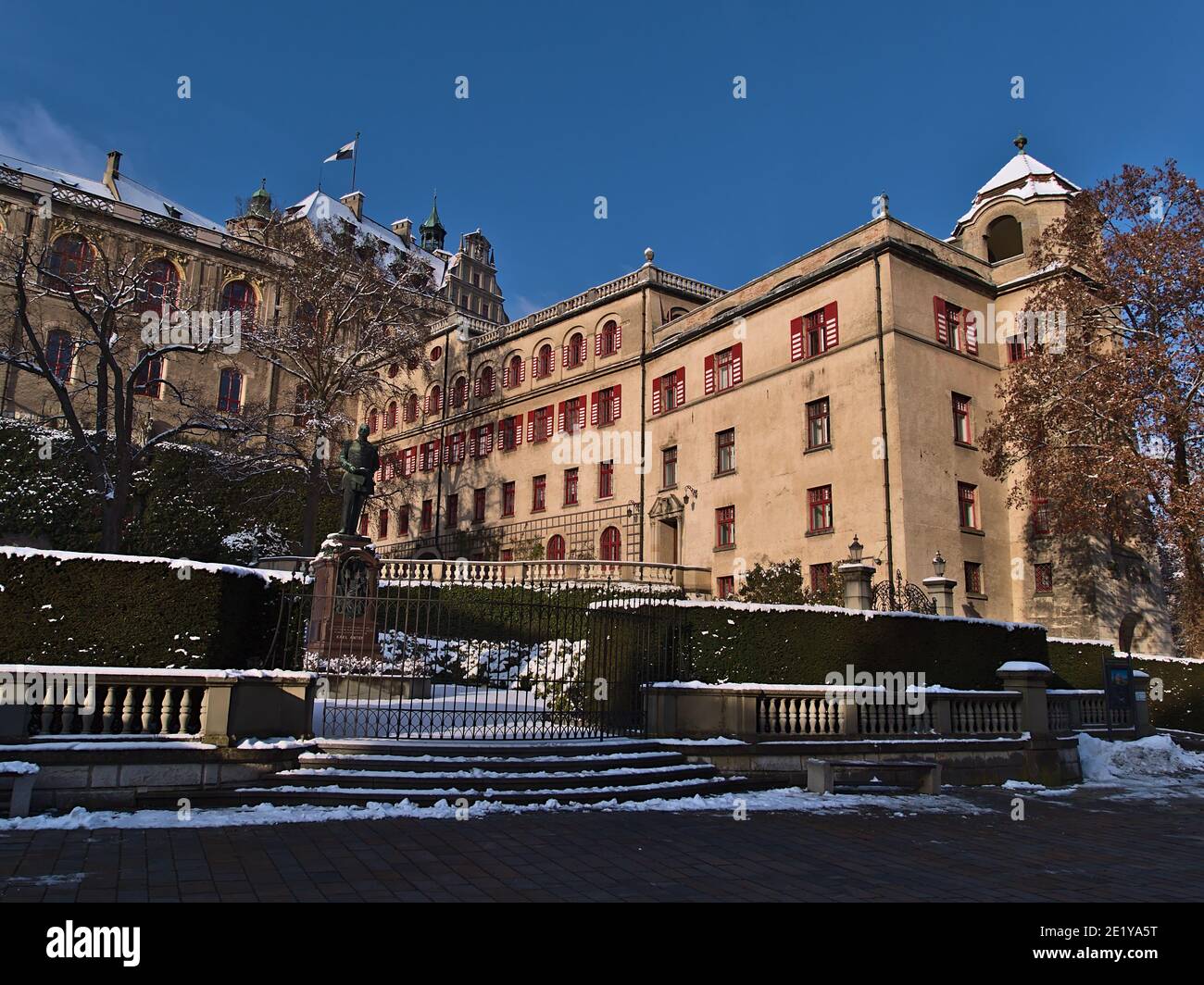 Vorderansicht des historischen Schlosses Hohenzollern mit Hecke, Zaun und alter Skulptur in der Stadt Sigmaringen, Baden-Württemberg, Deutschland am Abend. Stockfoto