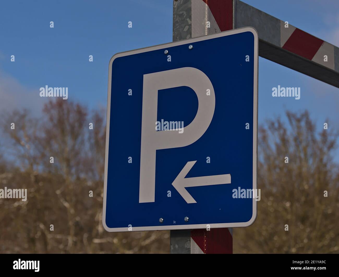 Nahaufnahme von blauem Parkschild mit weißem Buchstaben und Pfeil-Symbol (links) am Metalleingang des Parkhauses in Sigmaringen, Deutschland. Stockfoto
