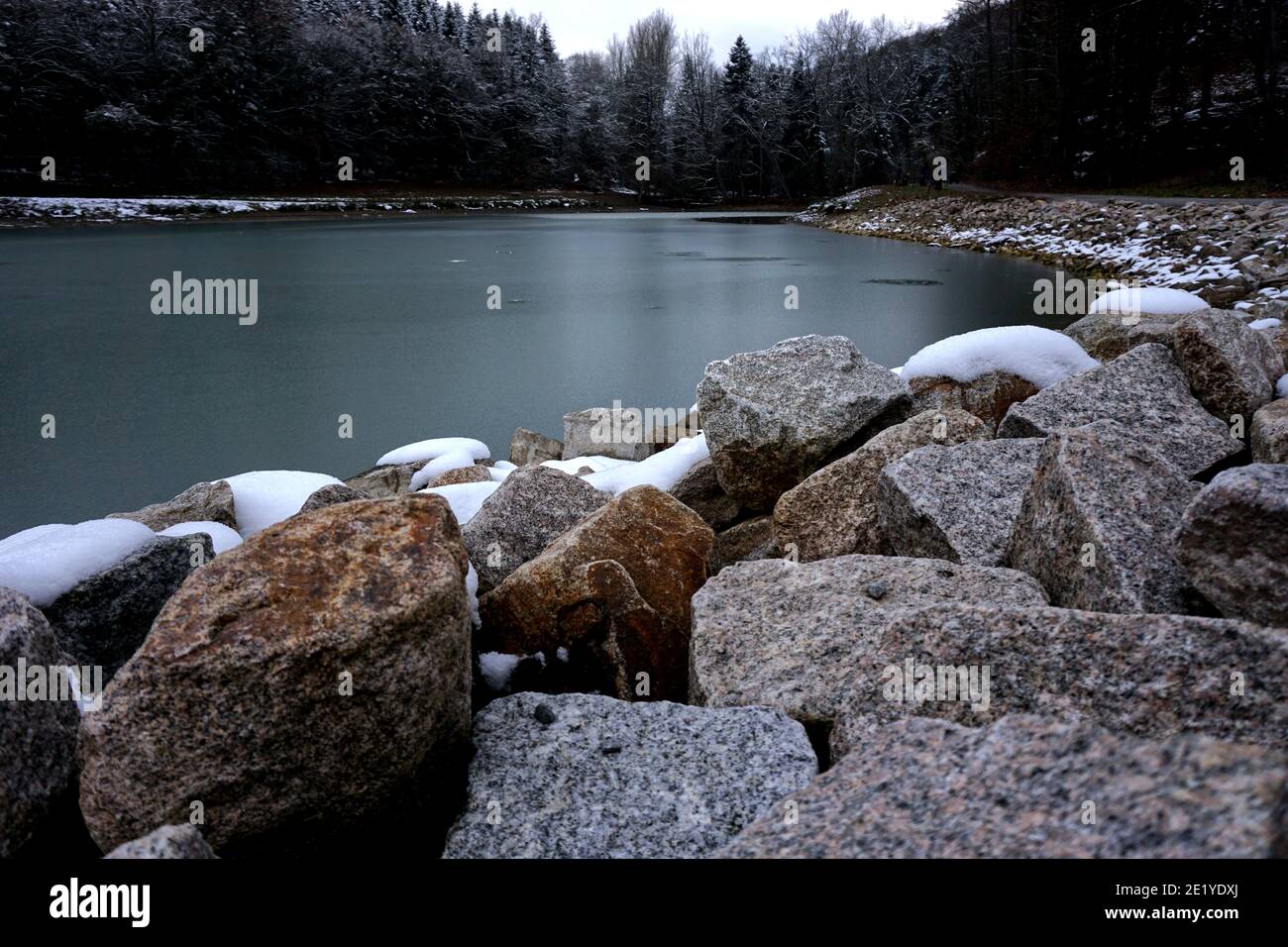 Felsen vor dem gefrorenen See Stockfoto