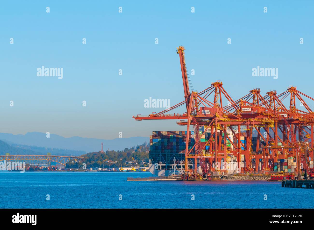 Hafen von Vancouver Blick vom Kohlehafen, Kraniche in rot an einem Industriehafen mit einer Brücke im Hintergrund. Selektiver Fokus, Straßenansicht, Reisefoto. Stockfoto