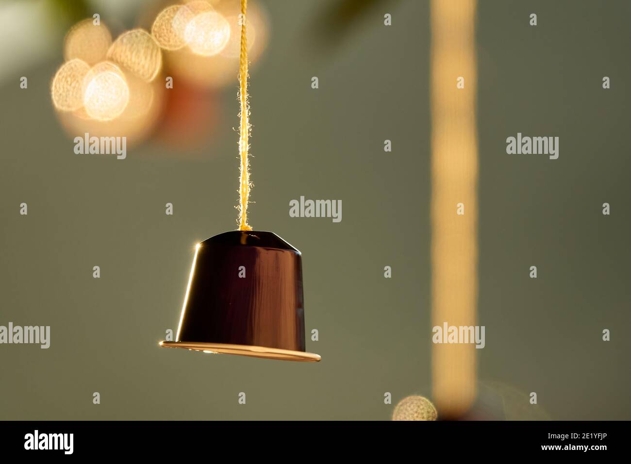 Original Gartendekoration: Bunte leere Kaffeekapseln hängen von den Blättern eines Baumes Stockfoto