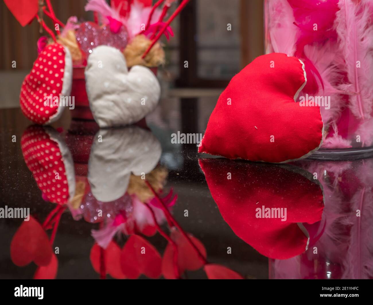 Ein rotes Herz spiegelt sich am Valentinstag im Klavier wider. Stockfoto
