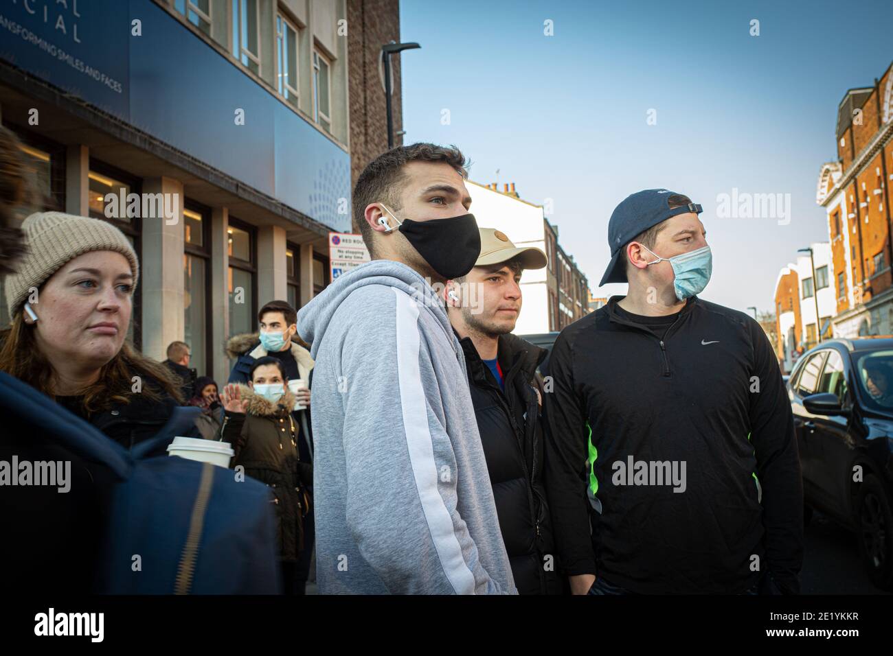 Menschen in schützenden Gesichtsmasken auf der Clapham High Street in London, England. Stockfoto