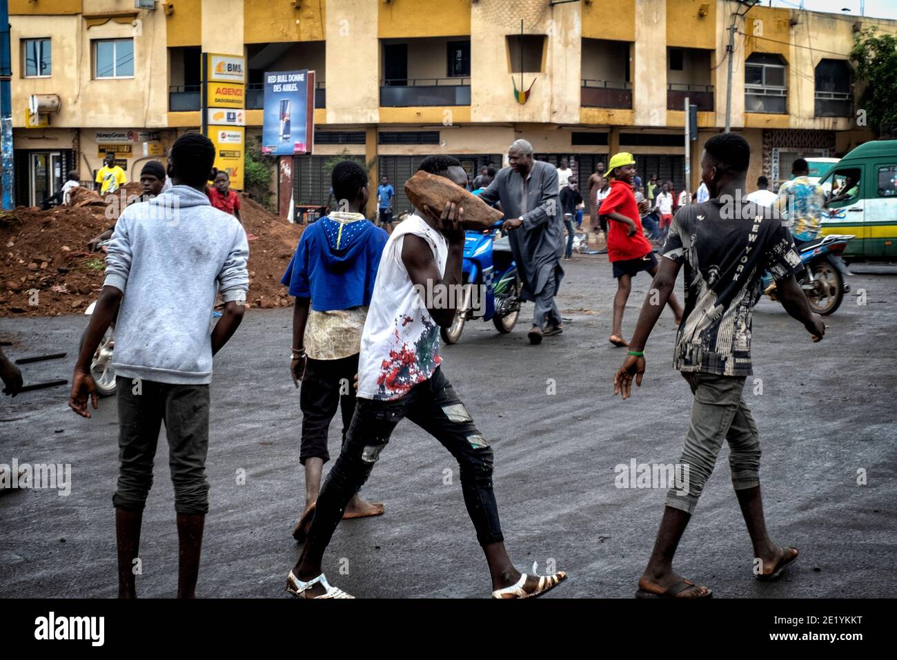 Ein Randalierer trägt einen Felsen während gewalttätiger Proteste in Bamako, Mali, 11. Juli 2020 Stockfoto