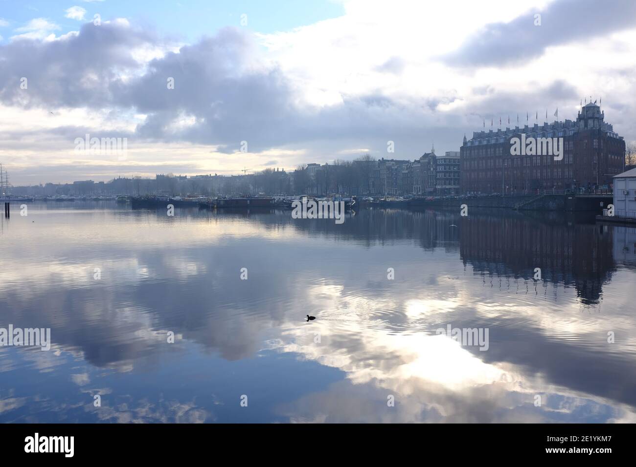 Amsterdam Holland/Niederlande – januari 2021: Amsterdam ohne Touristen und Einheimische aufgrund der Schließung von Cornoacrisis, die den Himmel im Wasser reflektiert Stockfoto