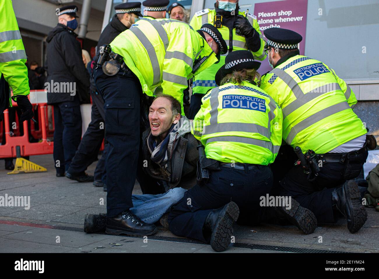 Ein Protestler wird von der Polizei in der Clapham High Street während der Anti-Lockdown-Demonstration am 9. Januar 2021 in London, England, verhaftet. Stockfoto