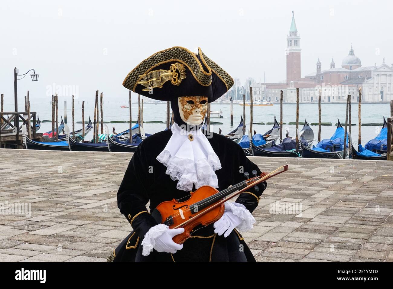 Mann in traditionell dekoriertem Kostüm und bemalter Maske während des Venedig Karnevals in Venedig, Italien Stockfoto